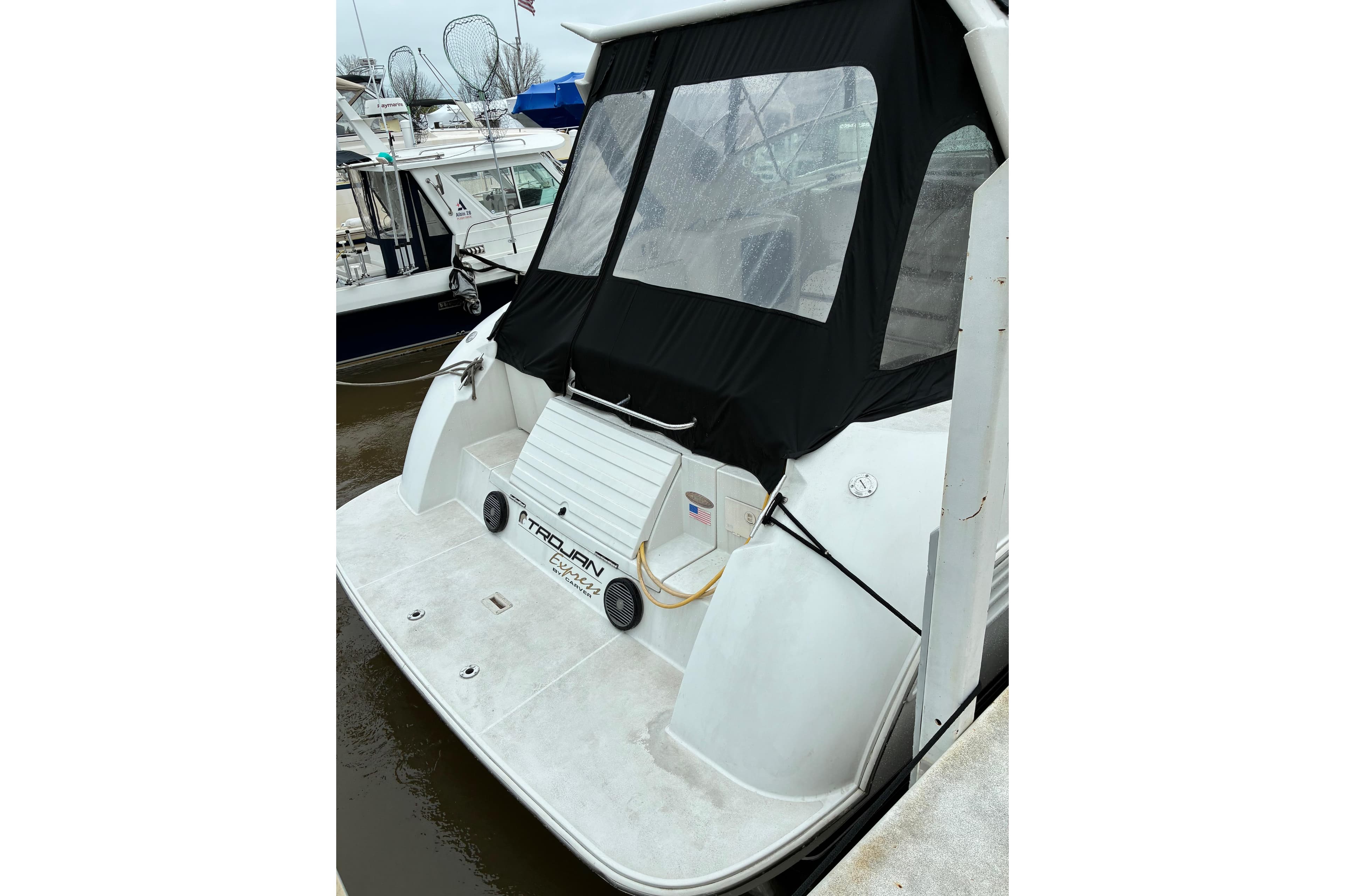1999 Trojan 360 Express yacht docked, featuring a covered rear deck and sleek design.