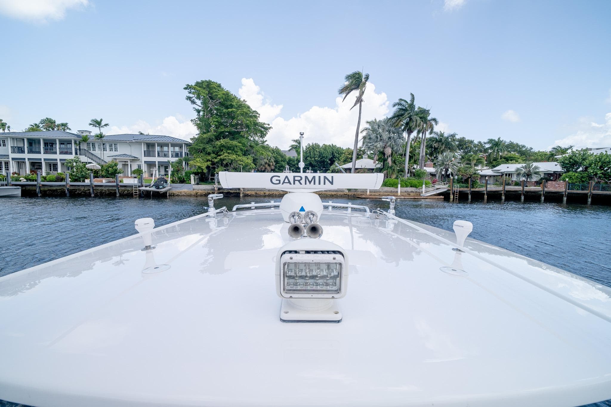 2021 Intrepid 400 Center Console boat with Garmin equipment, docked near waterfront homes.