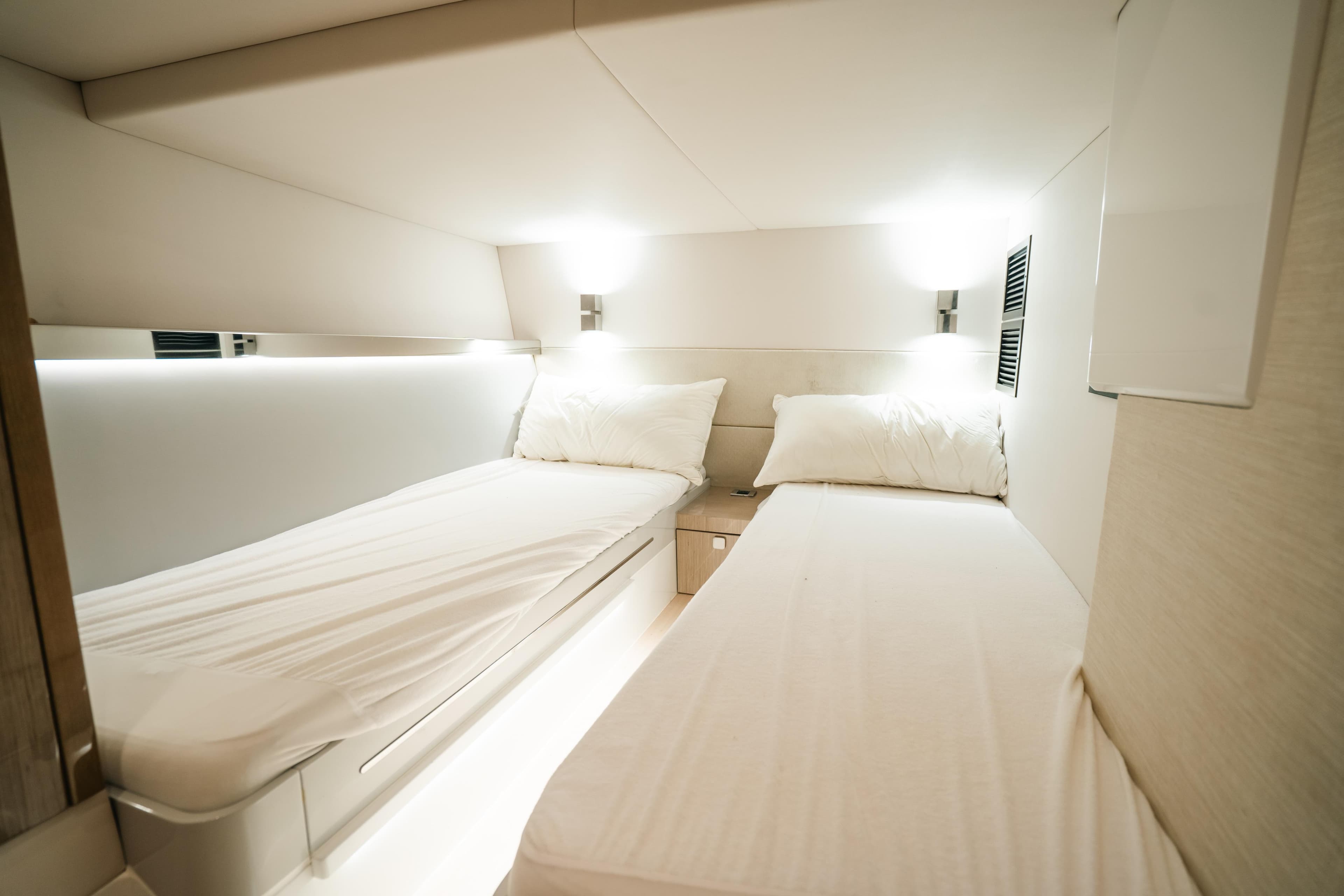 Luxurious twin cabin interior of 2022 Fjord 52 Open yacht, featuring modern design and ambient lighting.