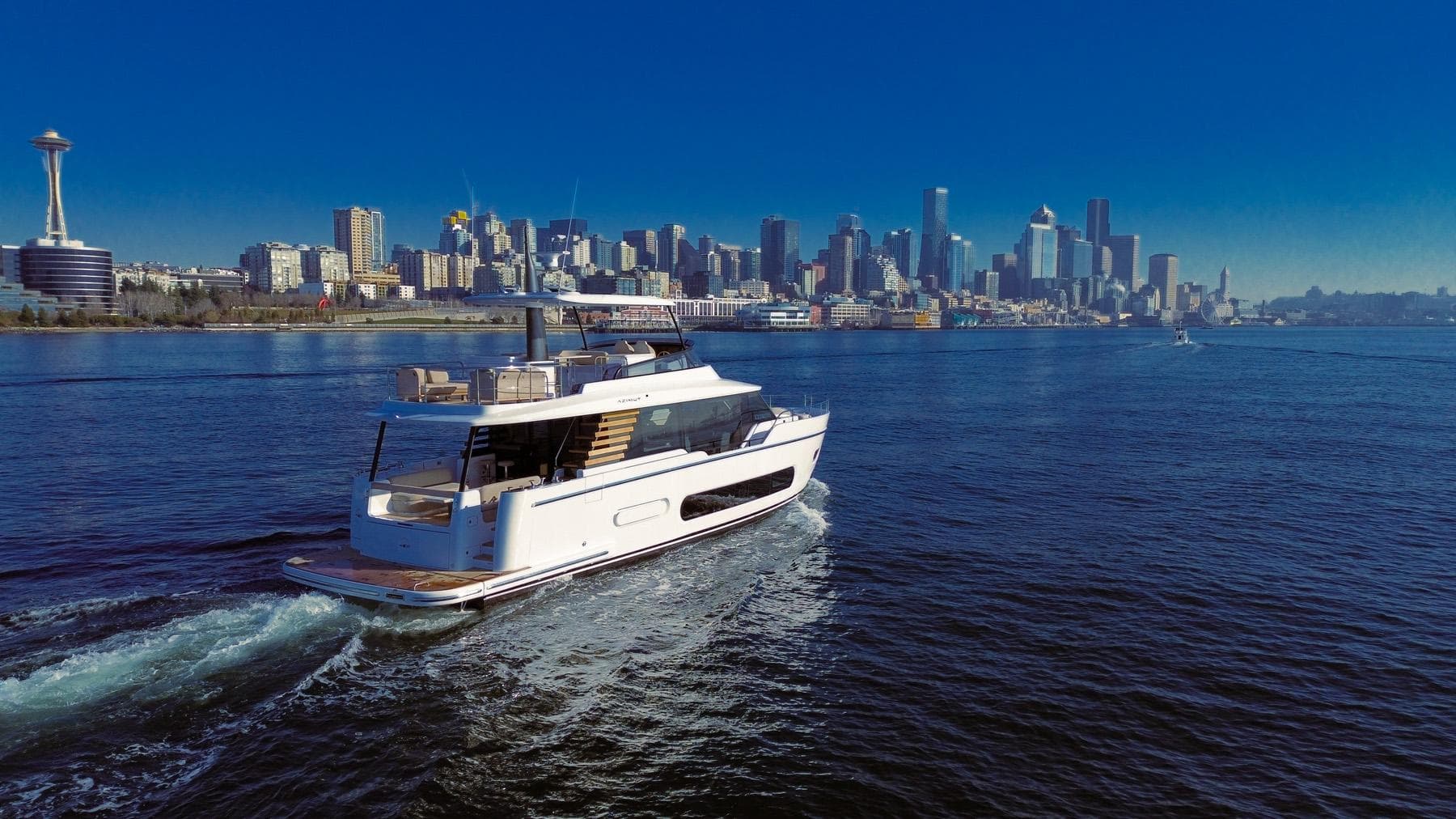 2025 Azimut Magellano 60 yacht cruising near a city skyline.