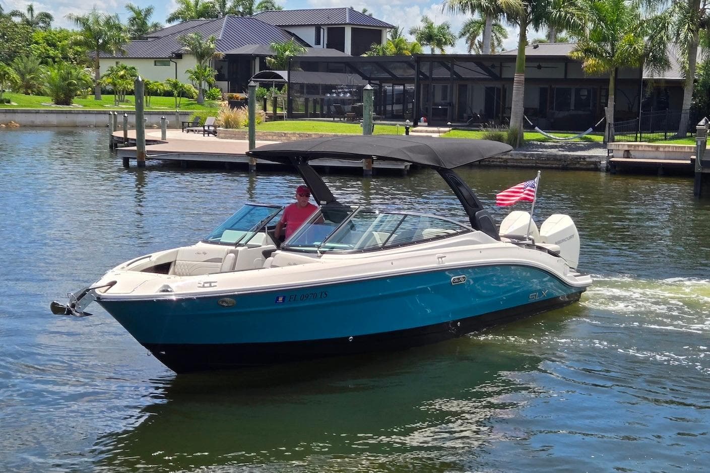 2023 Sea Ray SLX 280 Outboard cruising on a sunny day near waterfront homes.