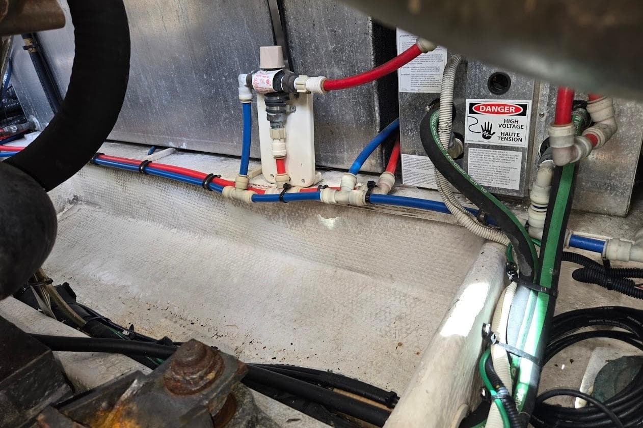 Engine compartment of 2009 Mainship Pilot 31 with wiring and high voltage warning.