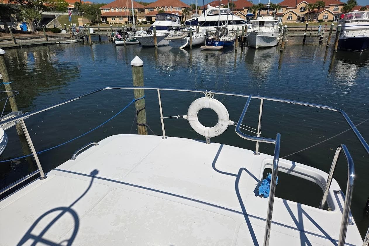 American Tug "34" Pilothouse Trawler, 2010, docked in a marina with other boats.