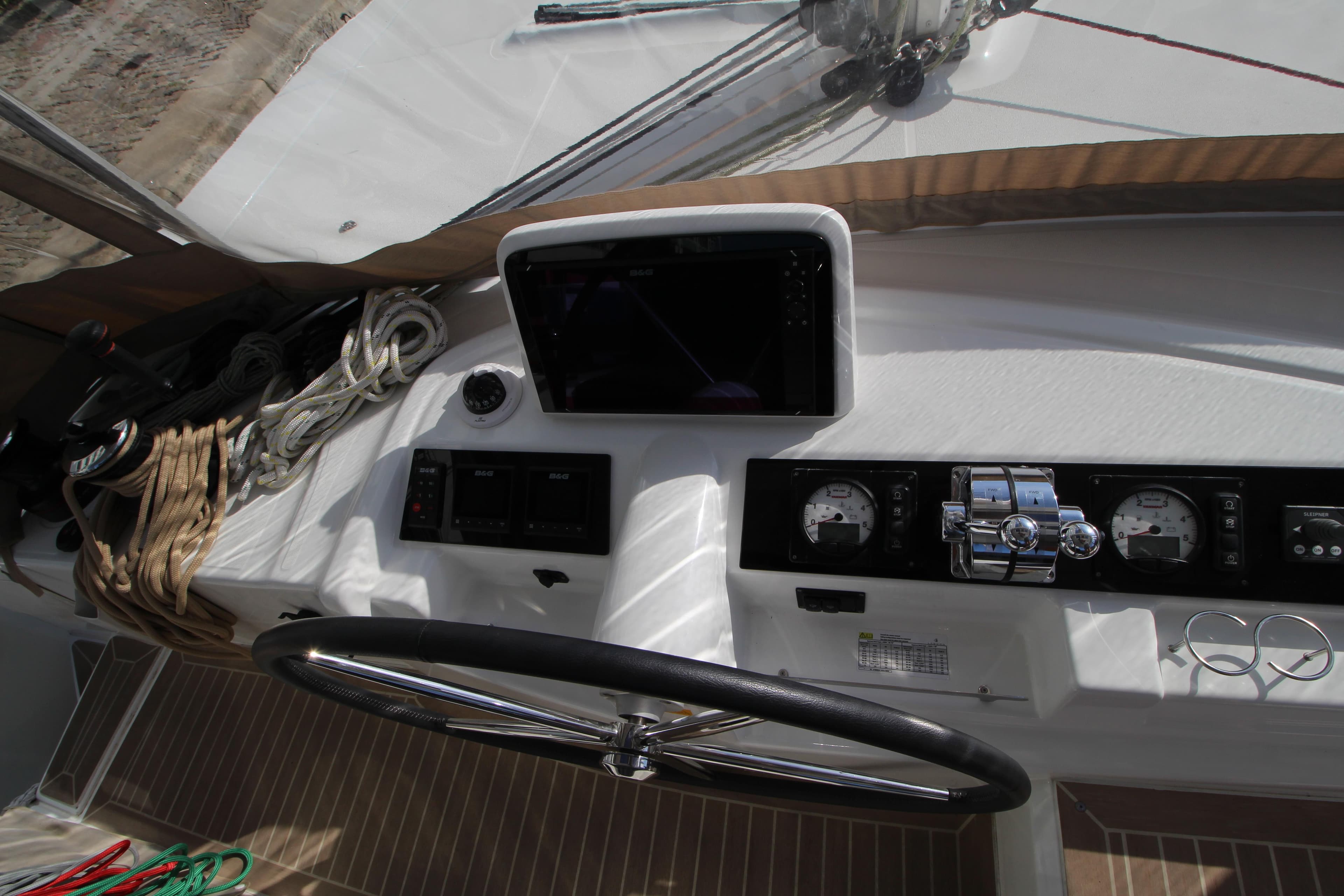 Cockpit of 2021 Lagoon 46 catamaran with steering wheel and navigation instruments.