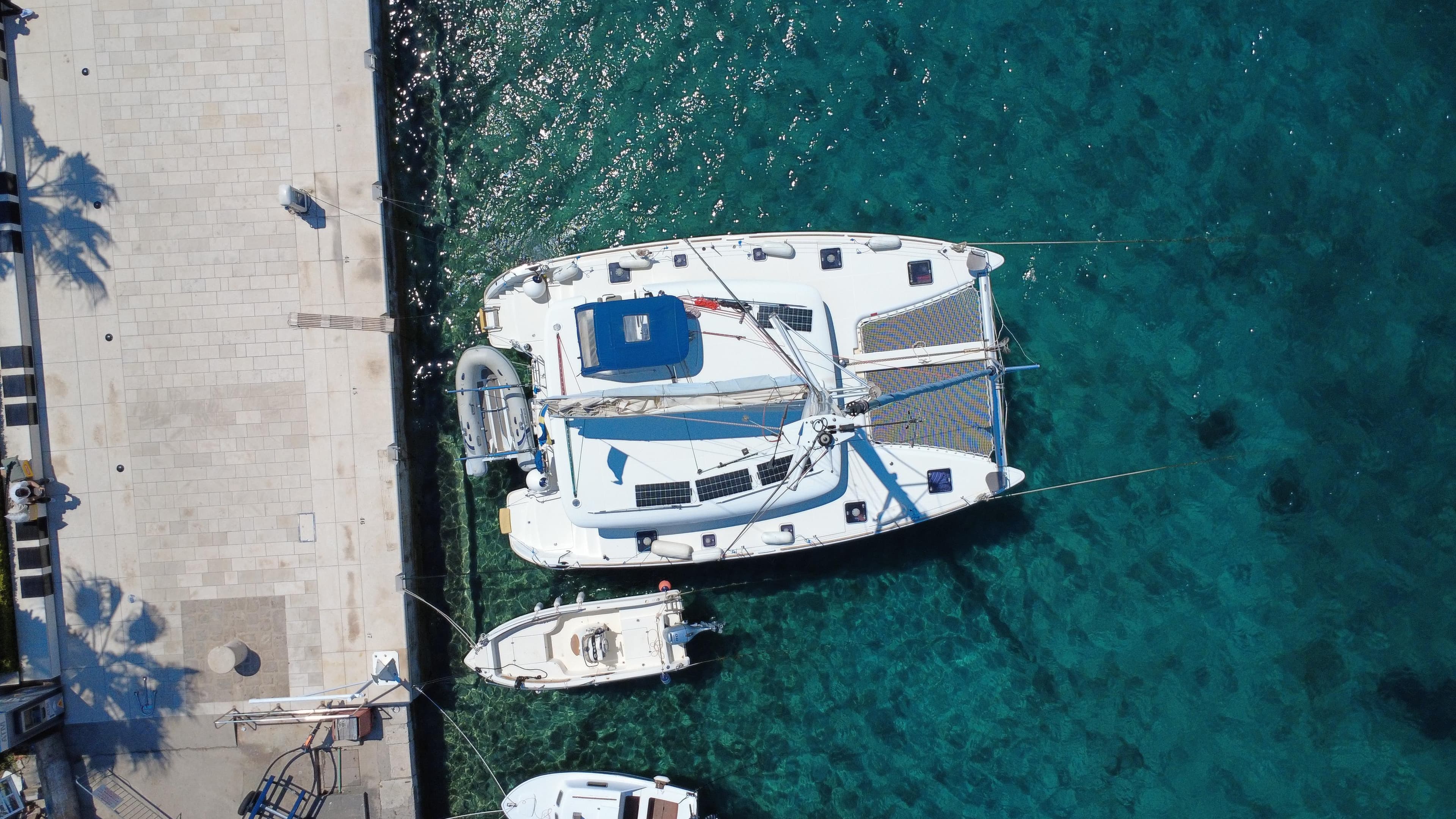 Aerial view of 2017 Lagoon 400 S2 catamaran docked in clear blue water.