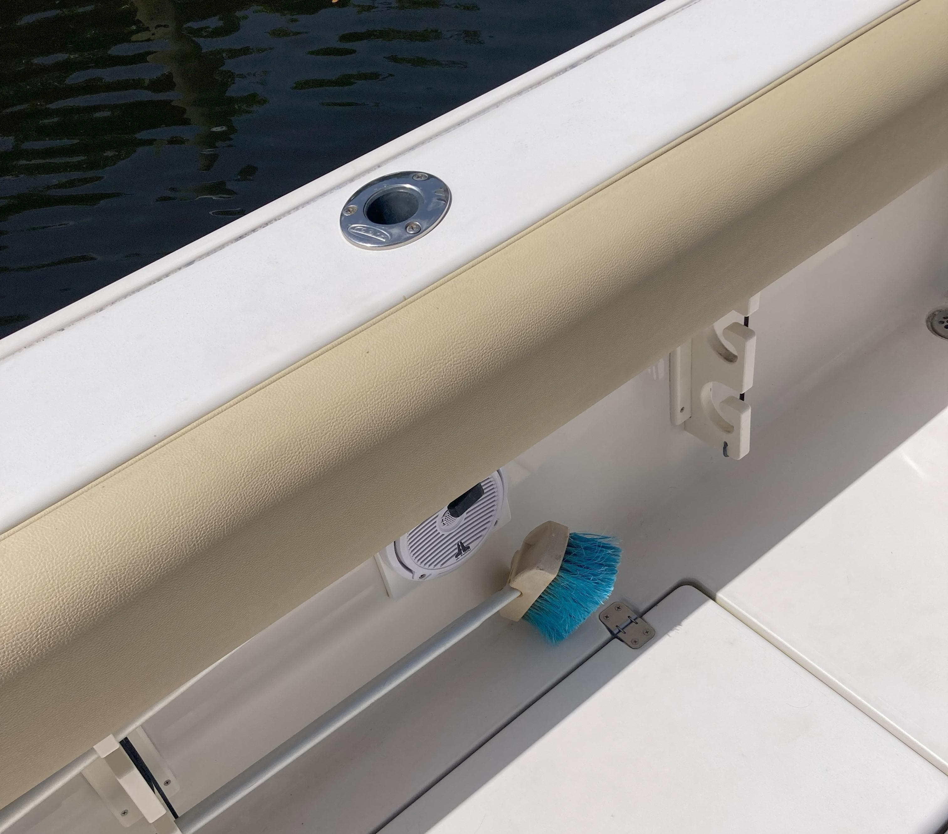 2008 Cobia 256 Center Console boat interior with a blue brush and beige padding.