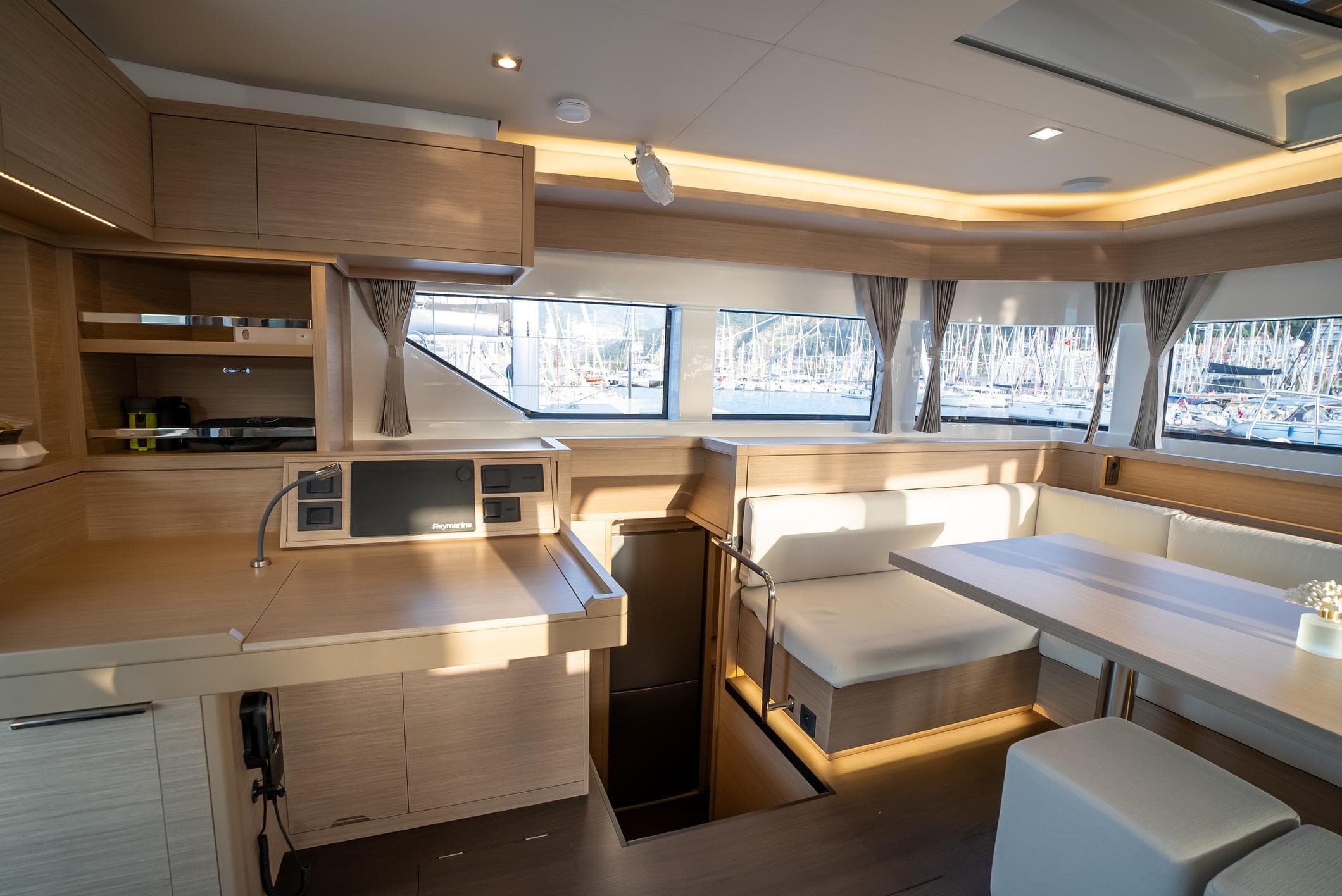 Luxurious interior of 2024 Lagoon 55 yacht with modern kitchen and dining area.