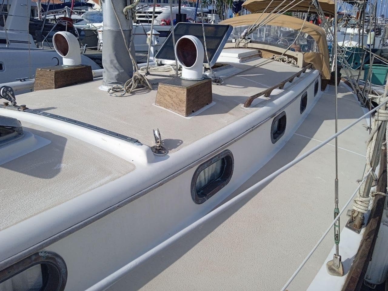 1983 Cape Dory 36 sailboat deck with portholes and rigging in a marina setting.