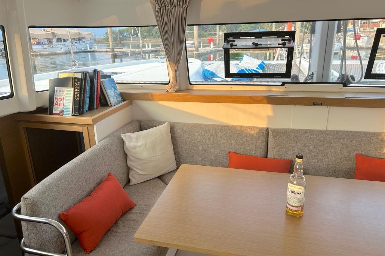 Interior of 2024 Excess 11 yacht with cozy seating and a bottle on the table.