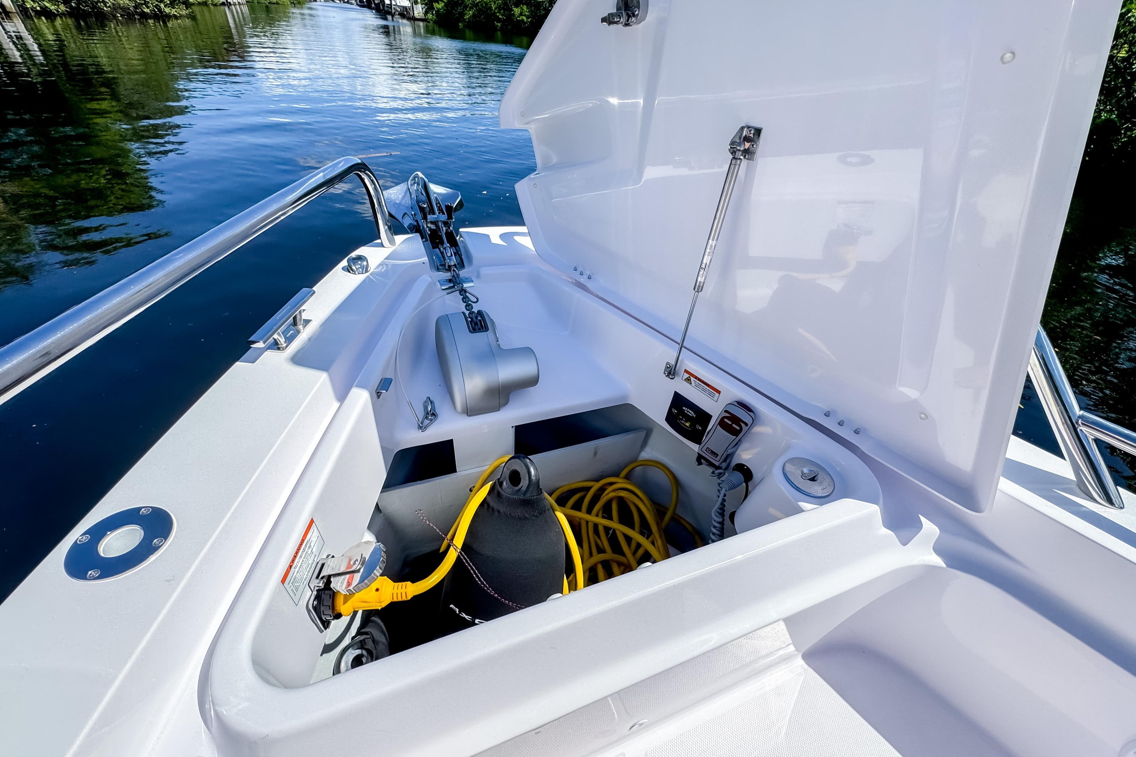 2024 Axopar 37 Sun Top boat storage compartment with equipment and yellow hose.