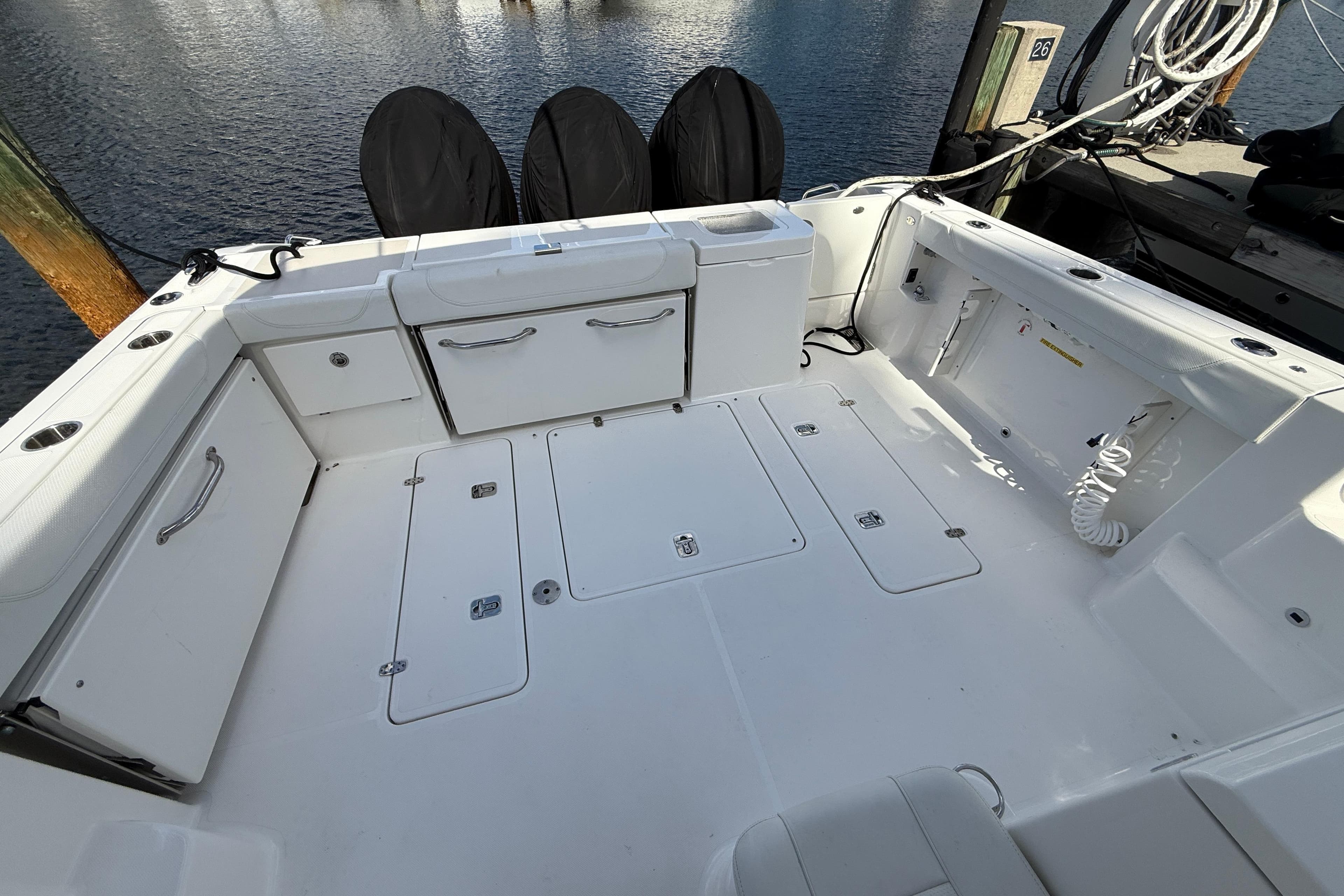 2023 Pursuit OS 355 Offshore boat deck with storage compartments and clean white finish.