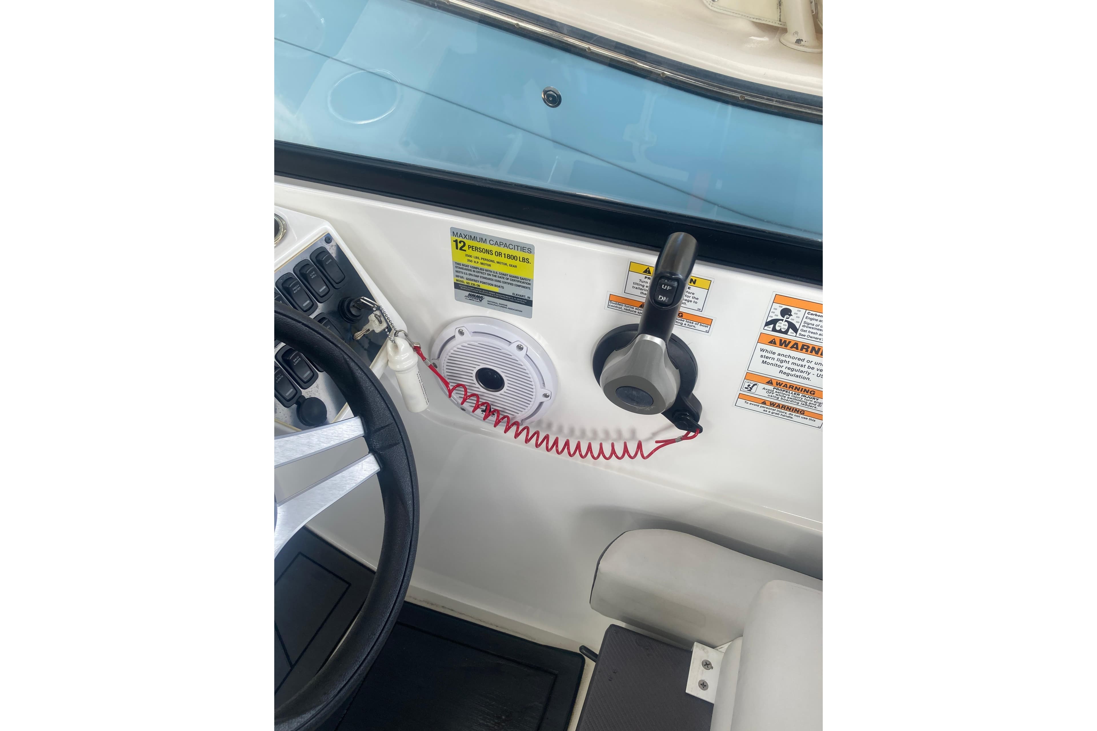 2023 Hurricane SunDeck 235 OB boat dashboard with steering wheel and control panel.