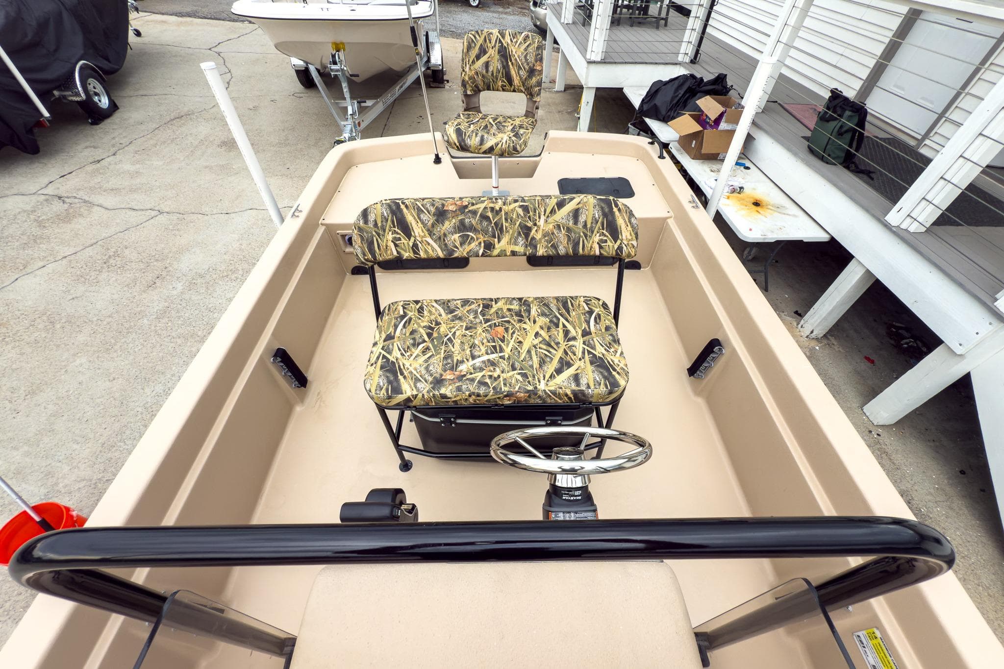 2026 Carolina Skiff E21 DLX CC boat with camo seats and steering wheel.
