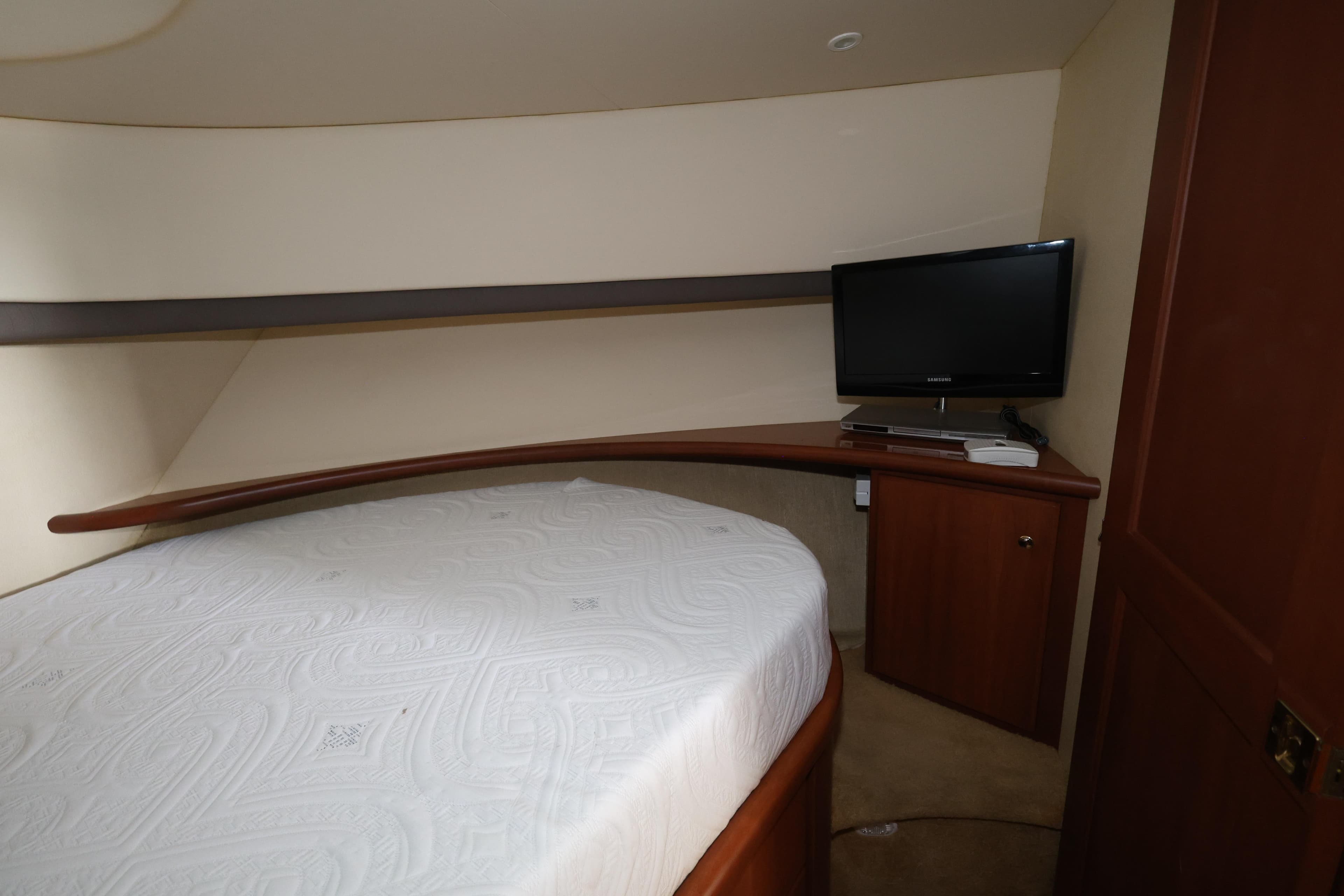 Interior cabin of 2005 Silverton 34 Convertible yacht with bed and TV.
