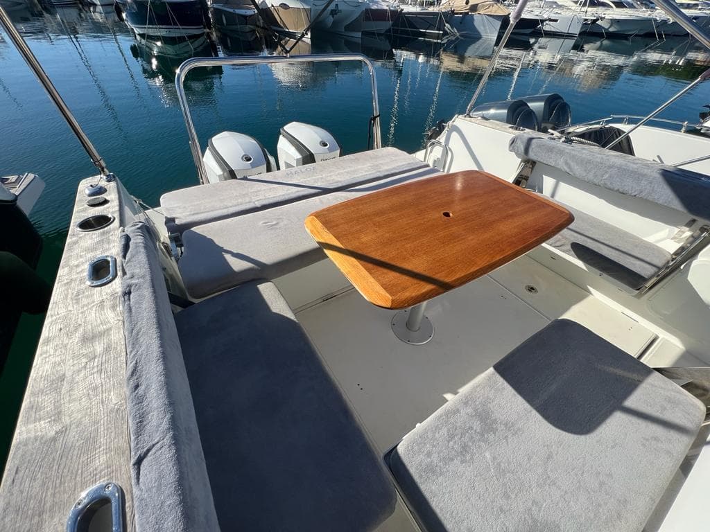2017 Beneteau Flyer 8.8 Sundeck with seating area and wooden table, docked at marina.