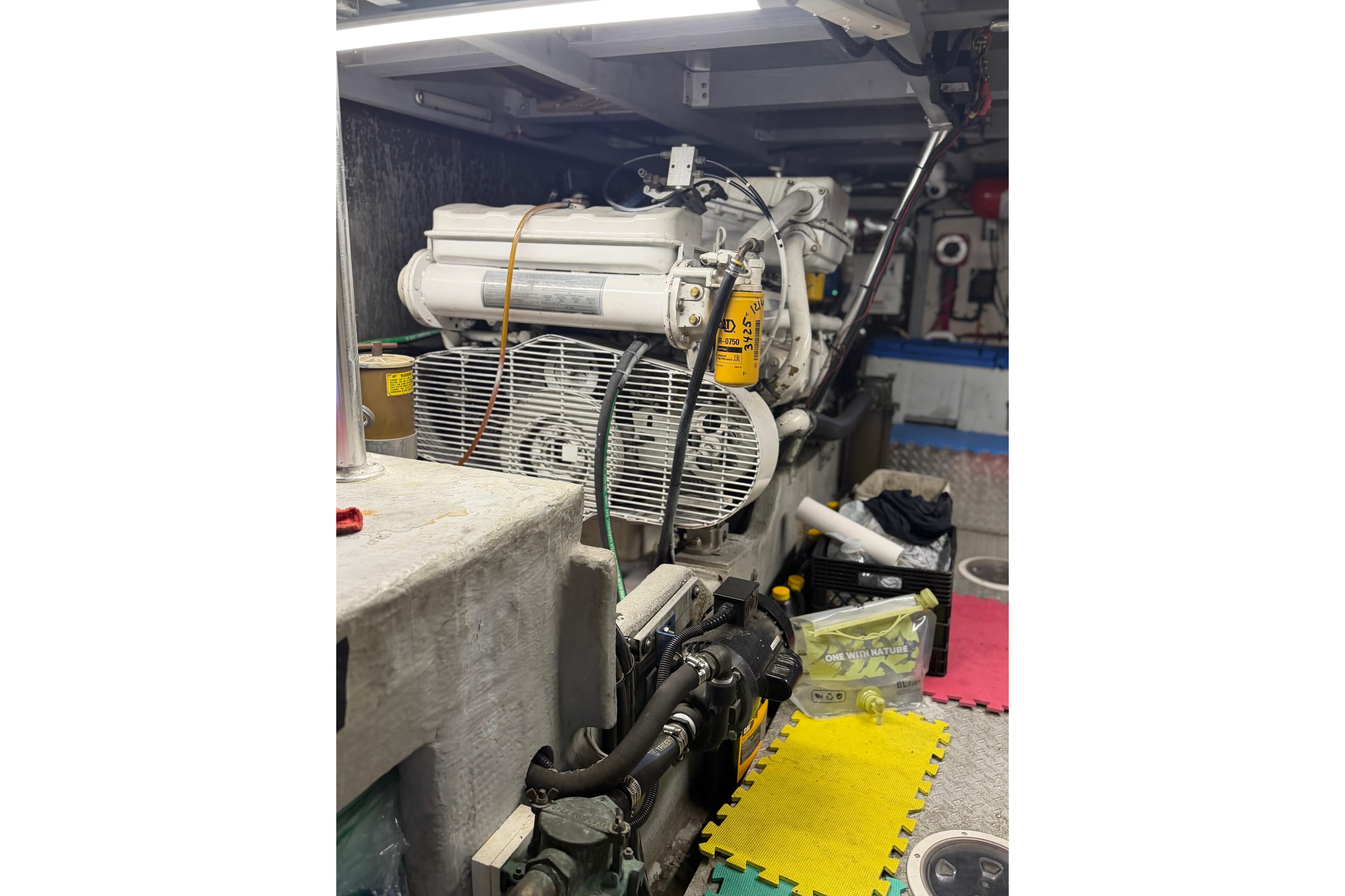 Engine room of a 1998 Mainship 47 Motor Yacht, showcasing mechanical components.
