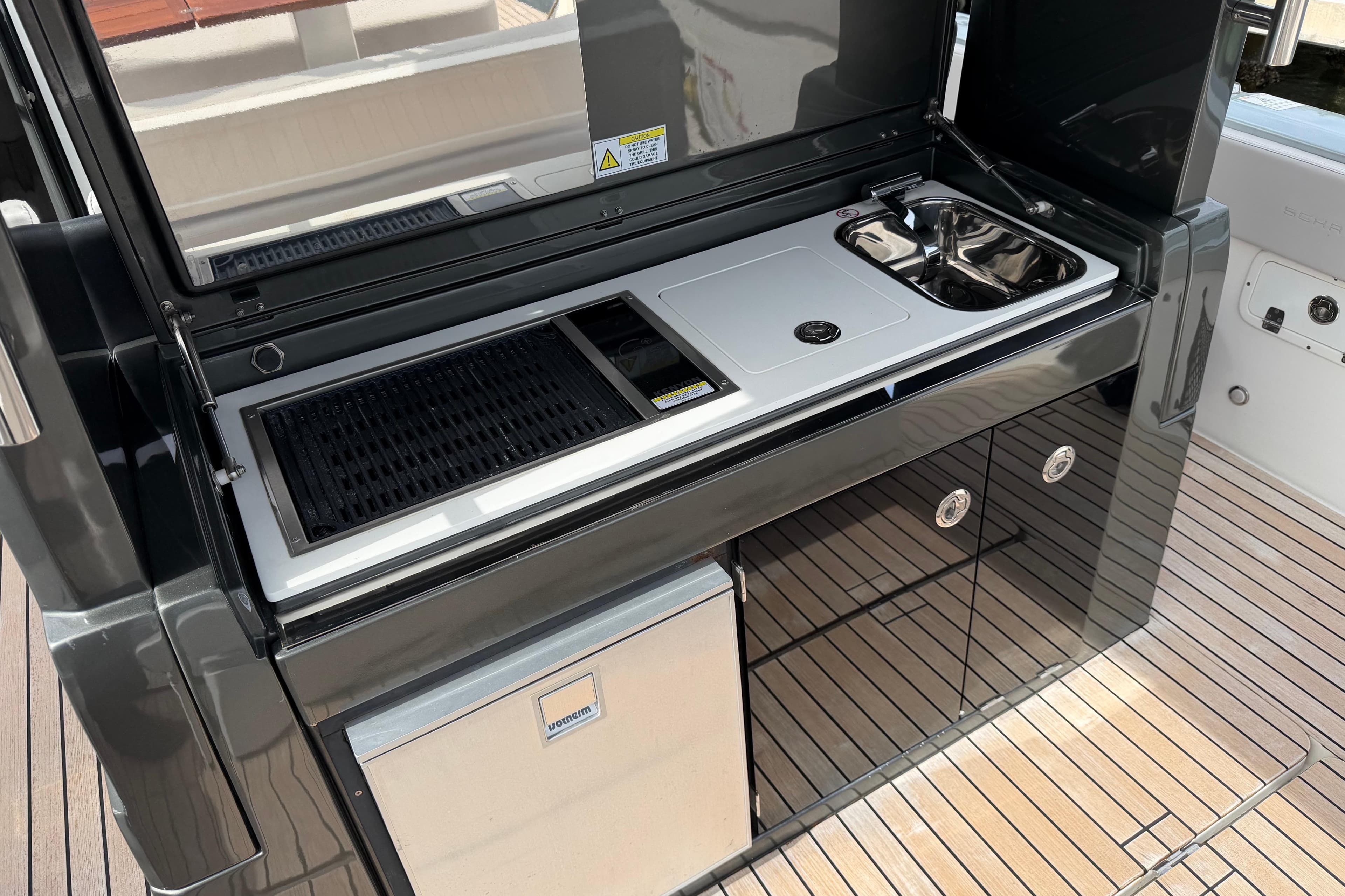 Outdoor kitchen on 2023 Schaefer V33 yacht with grill, sink, and storage.
