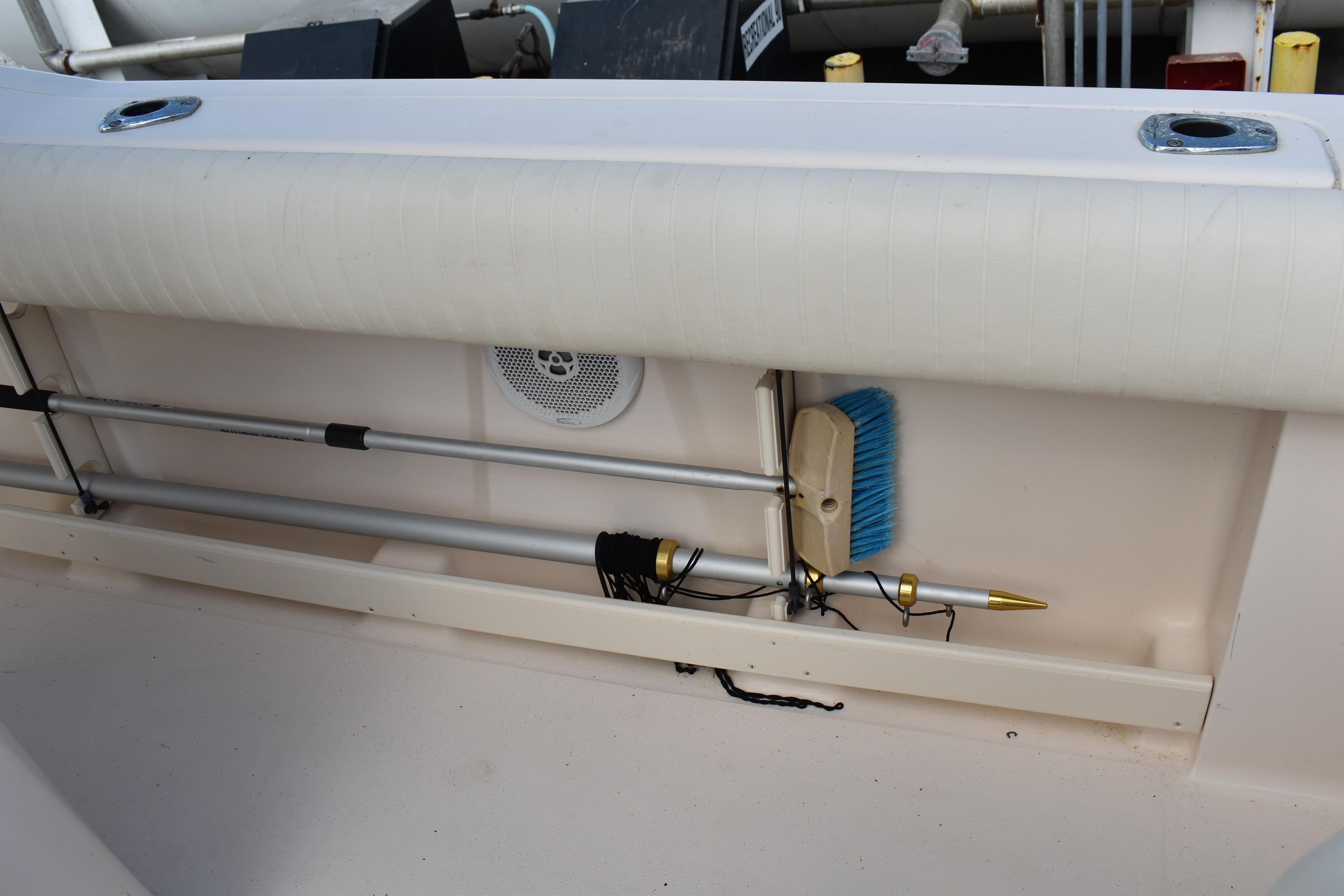 2012 Grady-White Canyon 271 boat storage area with cleaning tools and speaker.