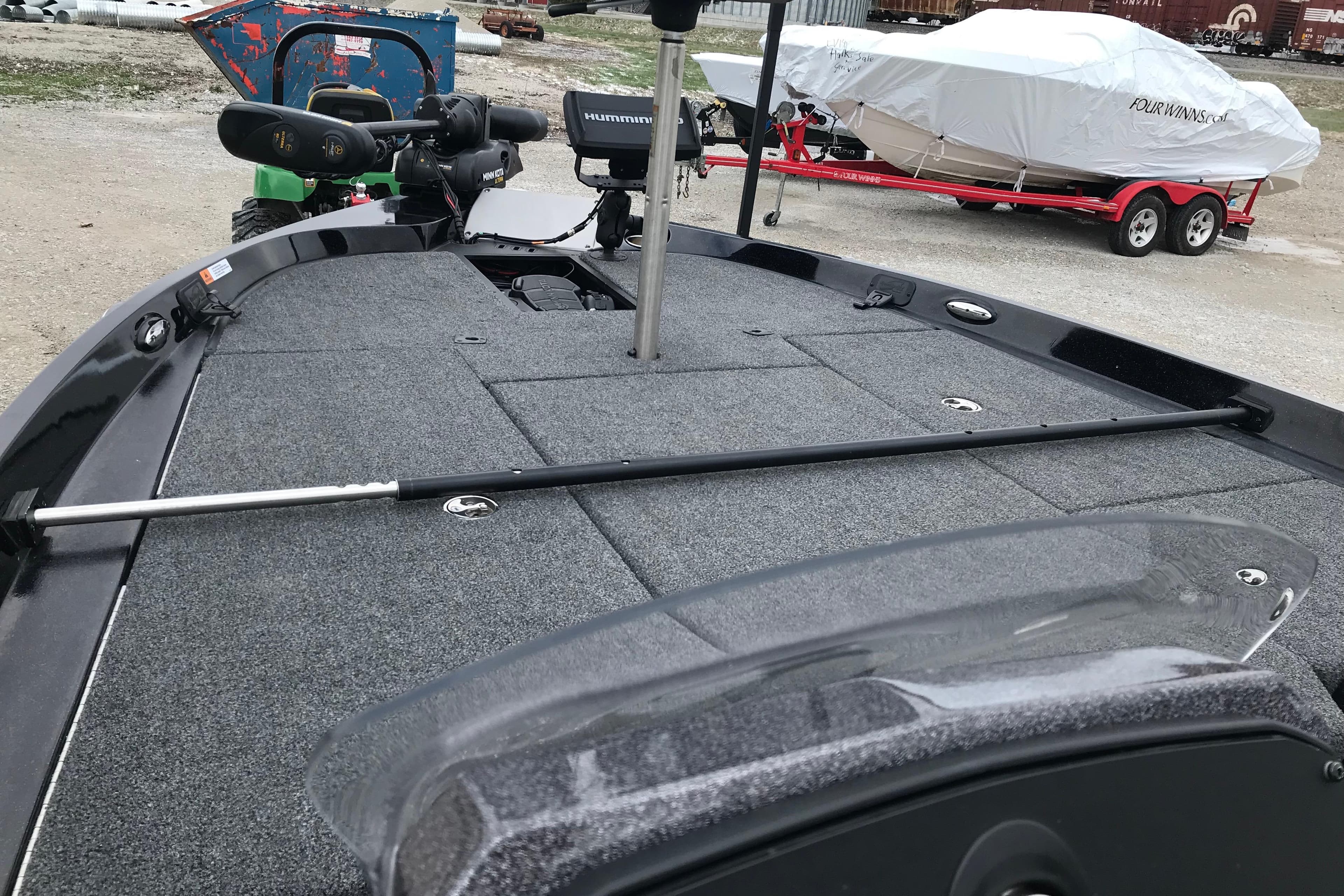 2022 Ranger Z185 boat deck with fishing equipment and covered boat in background.