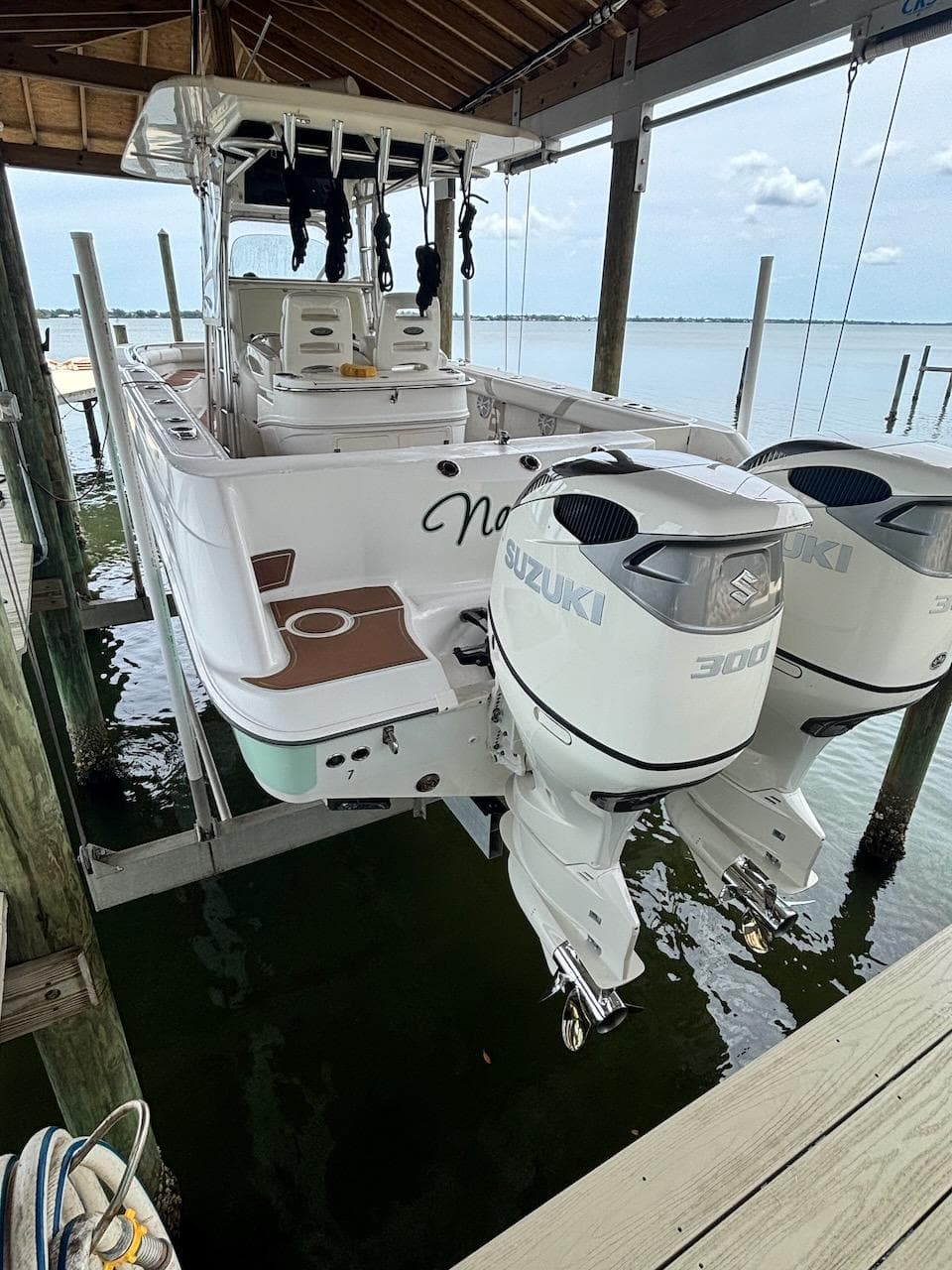 2006 Boston Whaler 320 Outrage with twin Suzuki 300 engines on a boat lift.