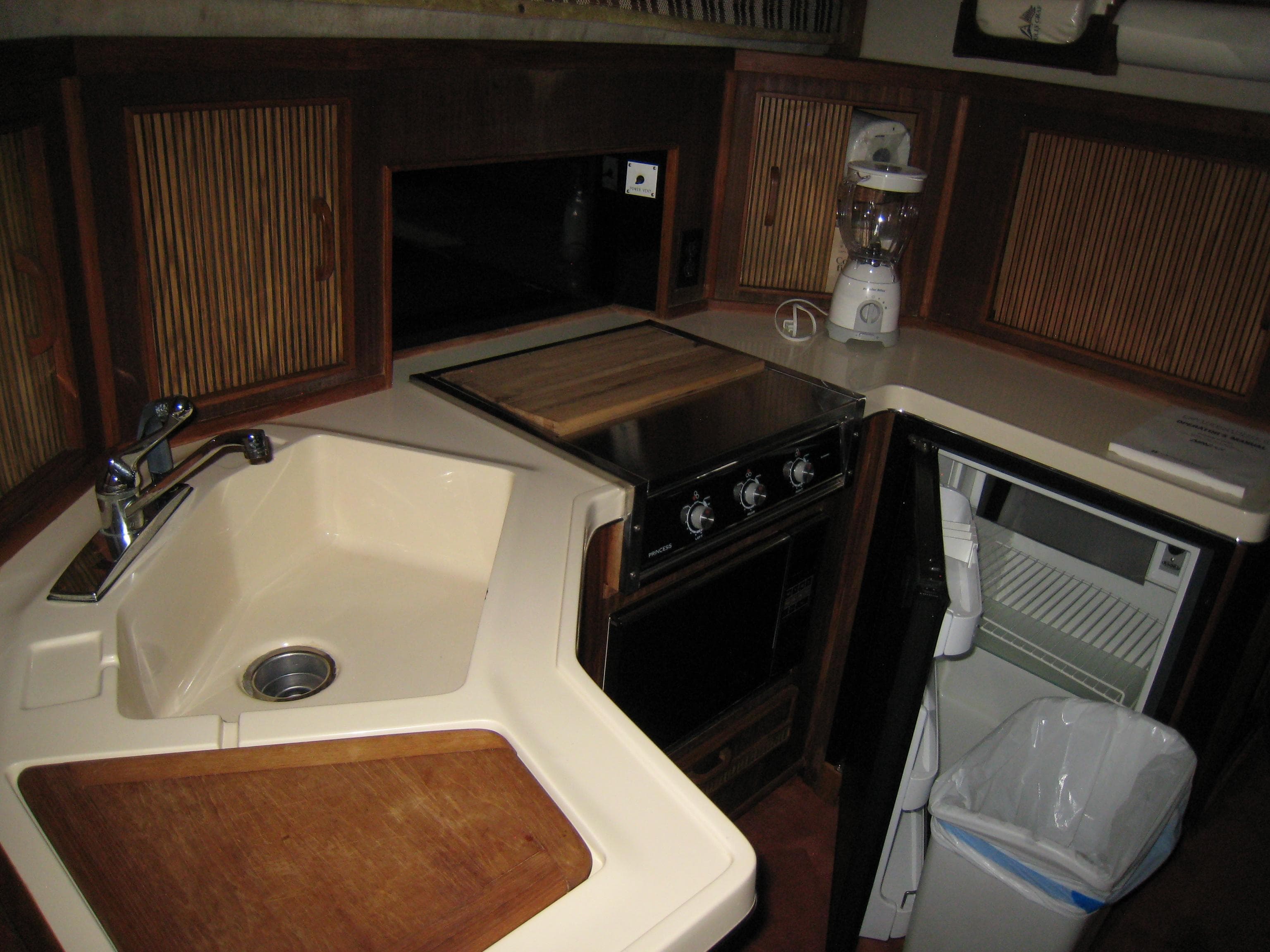 1986 Sea Ray 340 Express Cruiser kitchen with sink, stove, fridge, and blender.