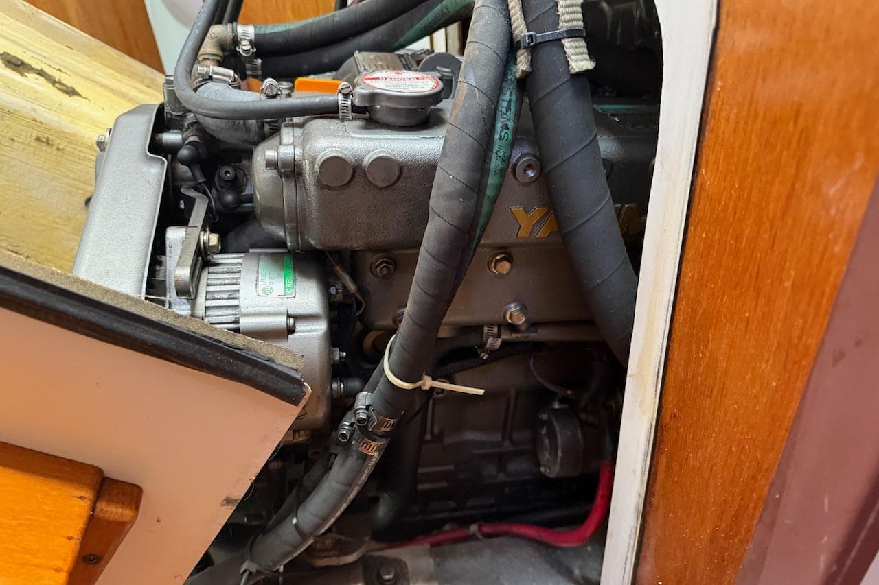 Engine compartment of a 1998 Catalina 380 sailboat, showcasing mechanical components and hoses.
