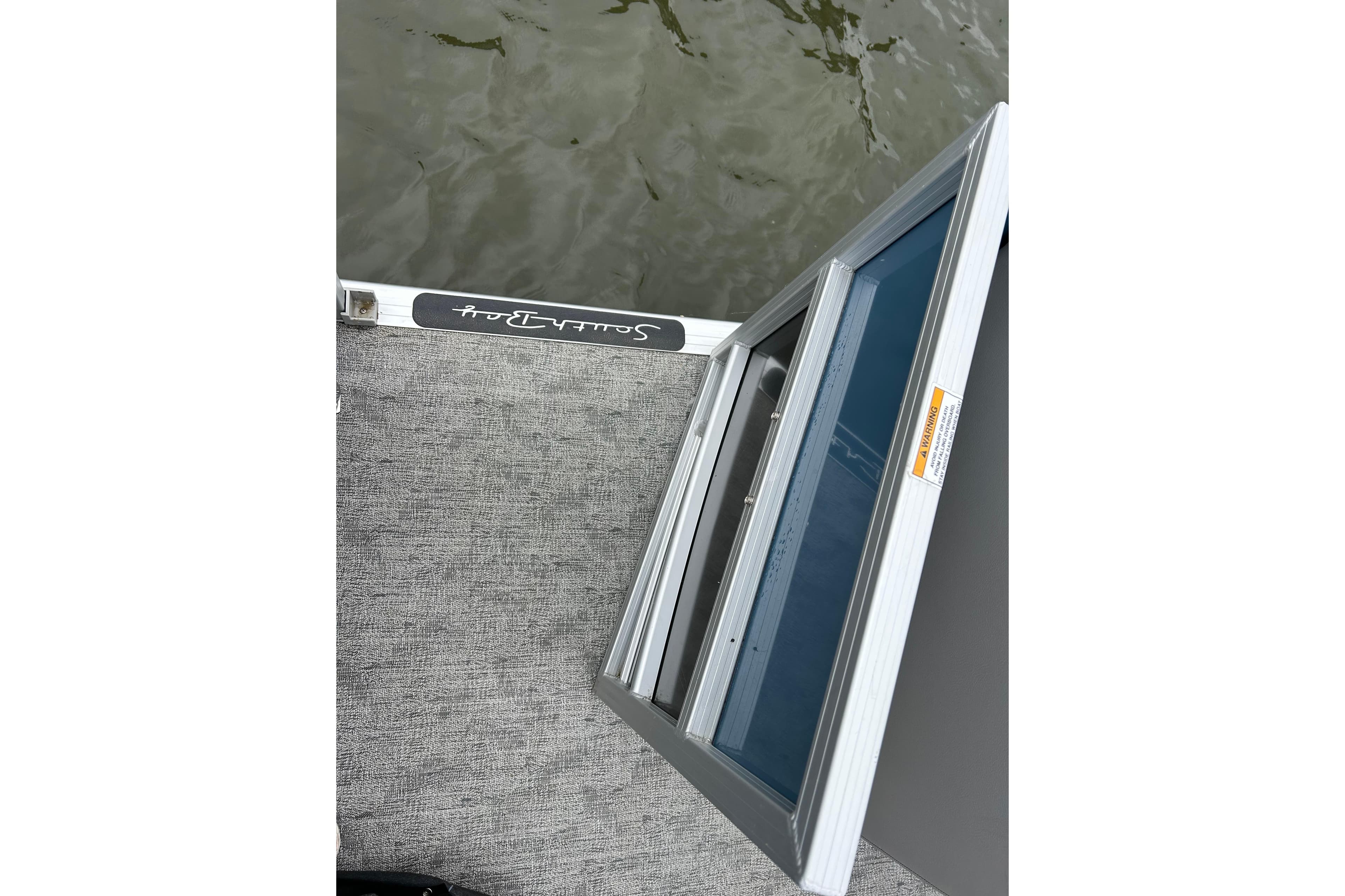 2025 Southbay 224RSLE275 boat deck with open hatch, near water surface.