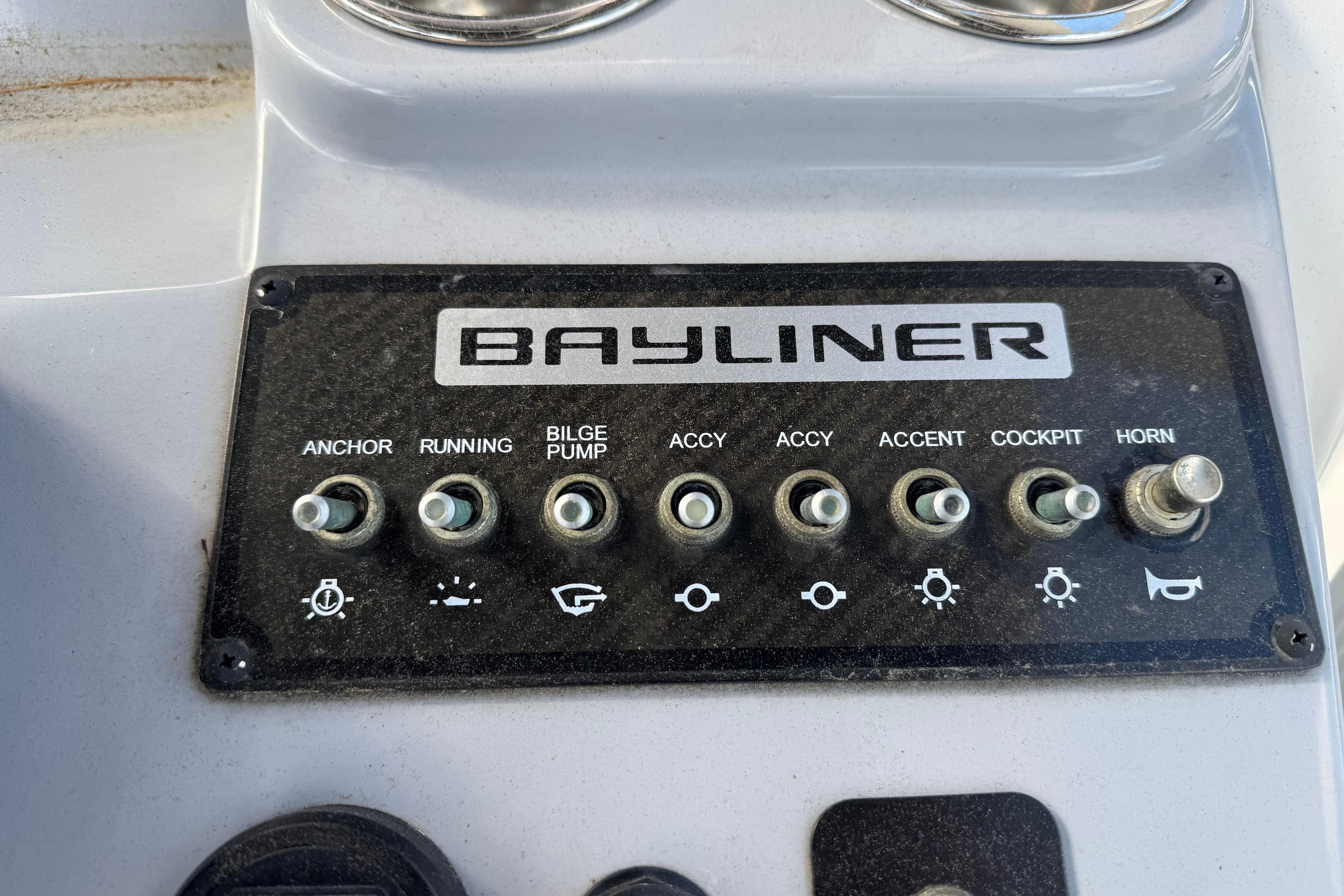 Control panel of a 2021 Trophy T22CX boat with various switches and Bayliner branding.