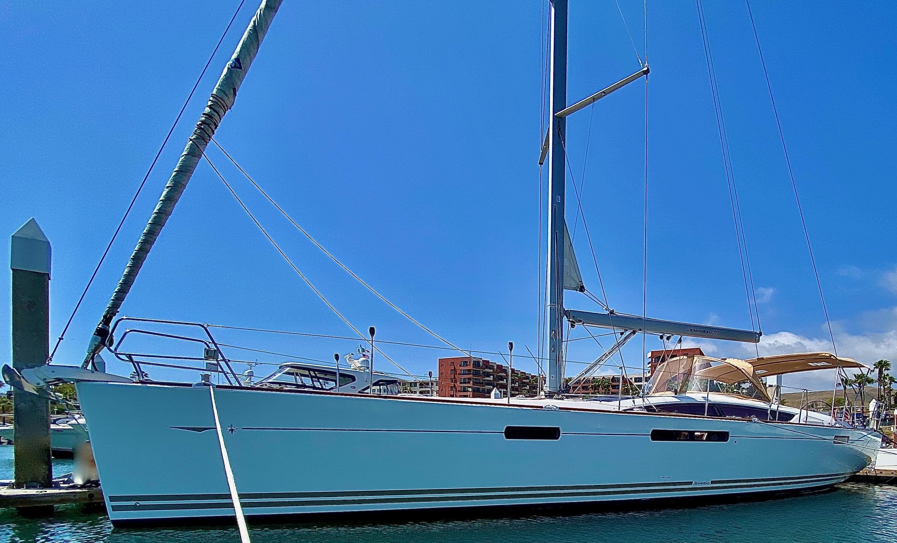 2014 Jeanneau 57 sailboat docked in marina under clear blue sky.