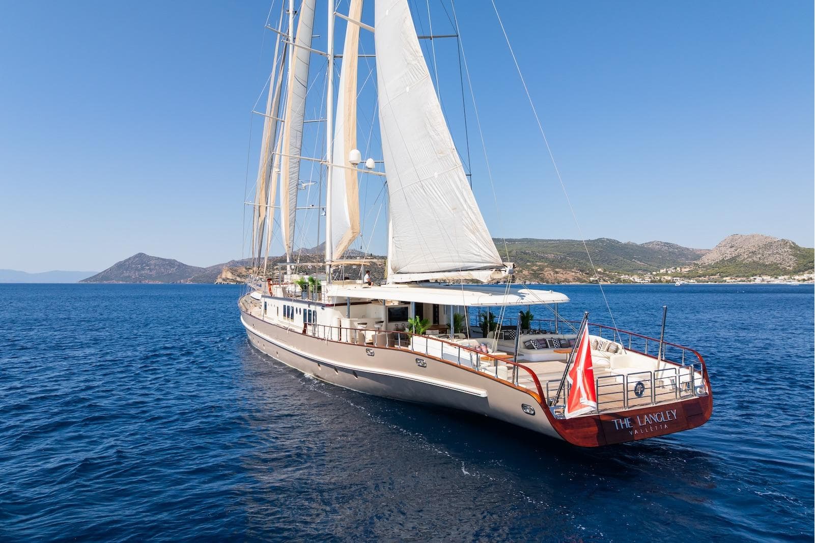 Aegean Yacht 3 Mast Schooner, 2009, sailing in clear blue waters near a scenic coastline.