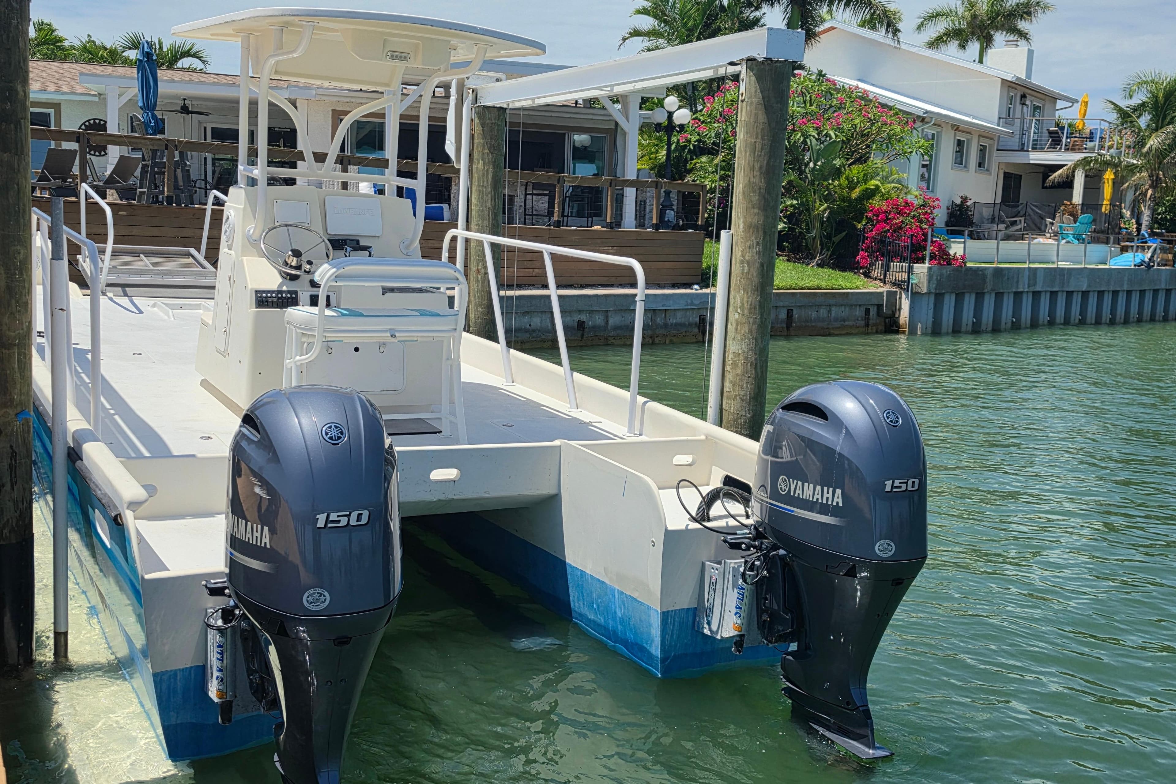 2014 Custom Exuma Catamaran 32 docked, featuring dual Yamaha 150 engines, in a scenic waterfront setting.