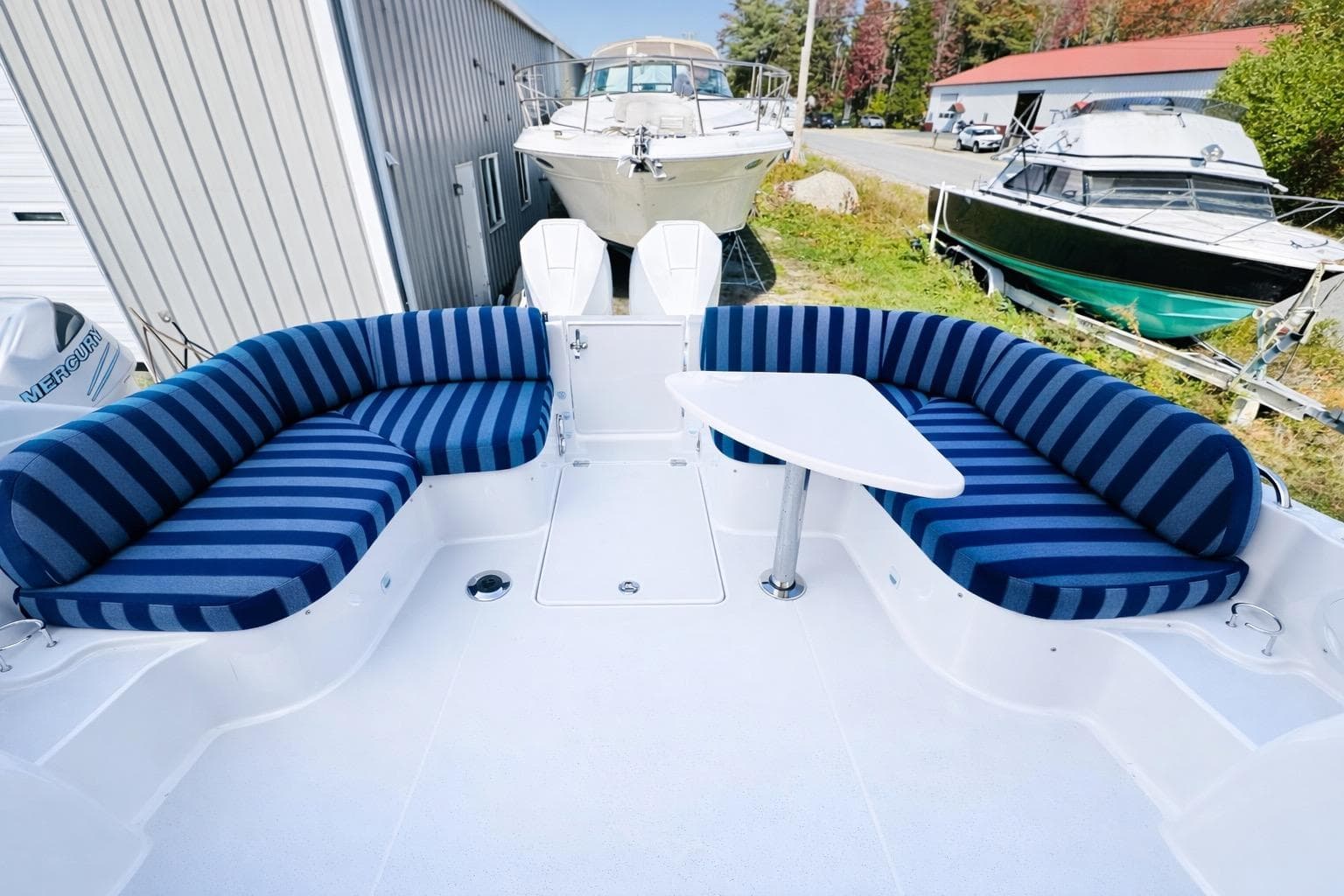 2024 Back Cove 34O boat with striped seating and table, docked outdoors.