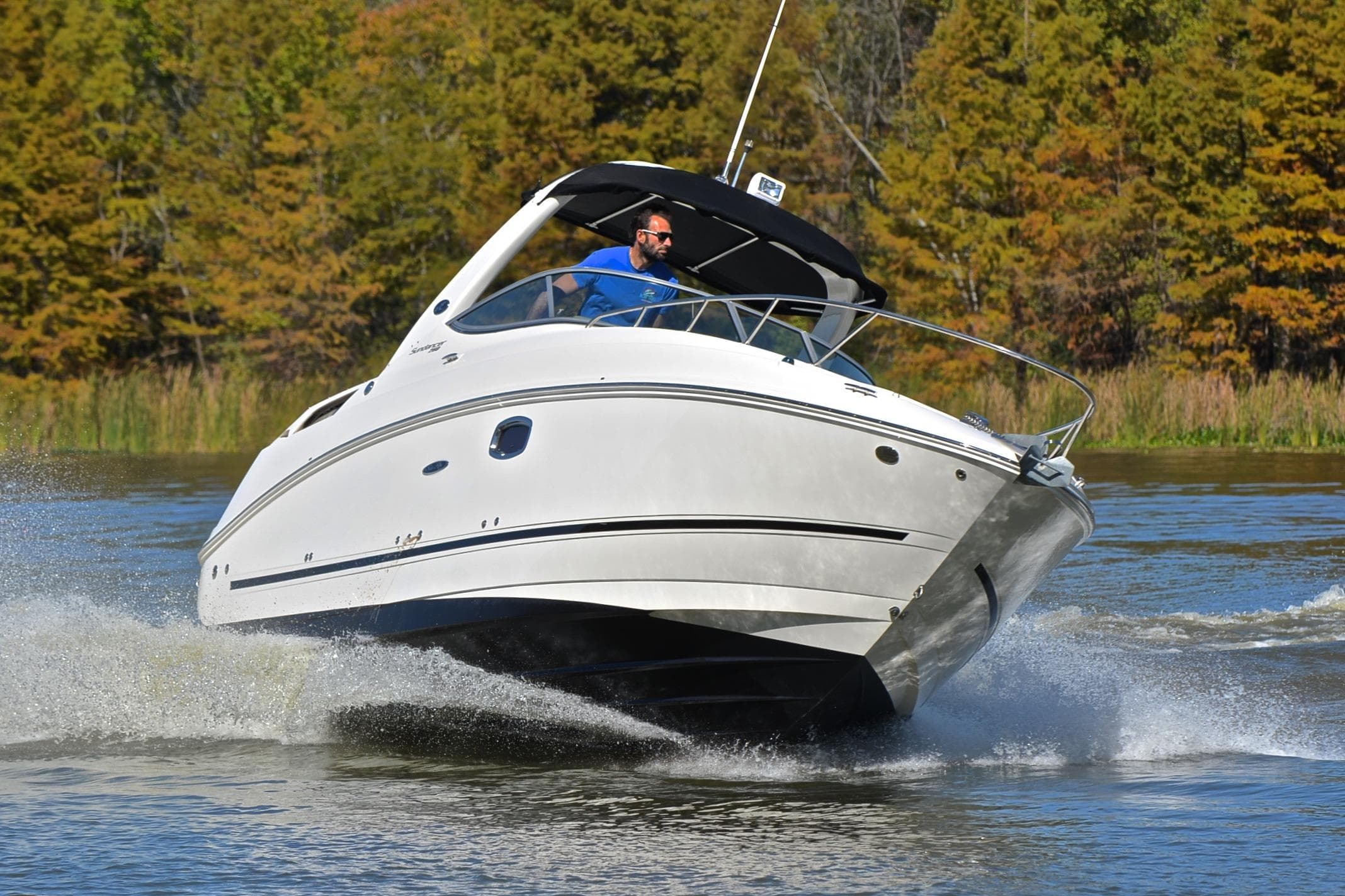 2011 Sea Ray 260 Sundancer cruising on a scenic lake with trees in the background.