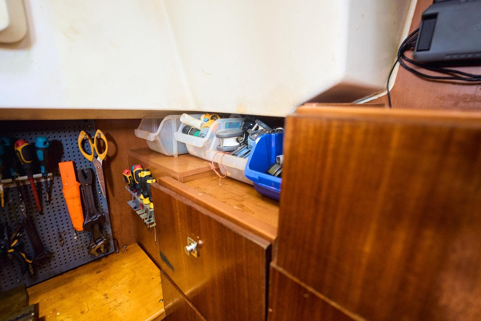 Workshop area on a 2014 Beneteau Oceanis 48 sailboat with tools and storage bins.