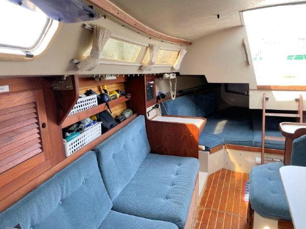 Interior of 1988 Catalina 30 MkII sailboat with blue seating and wooden accents.