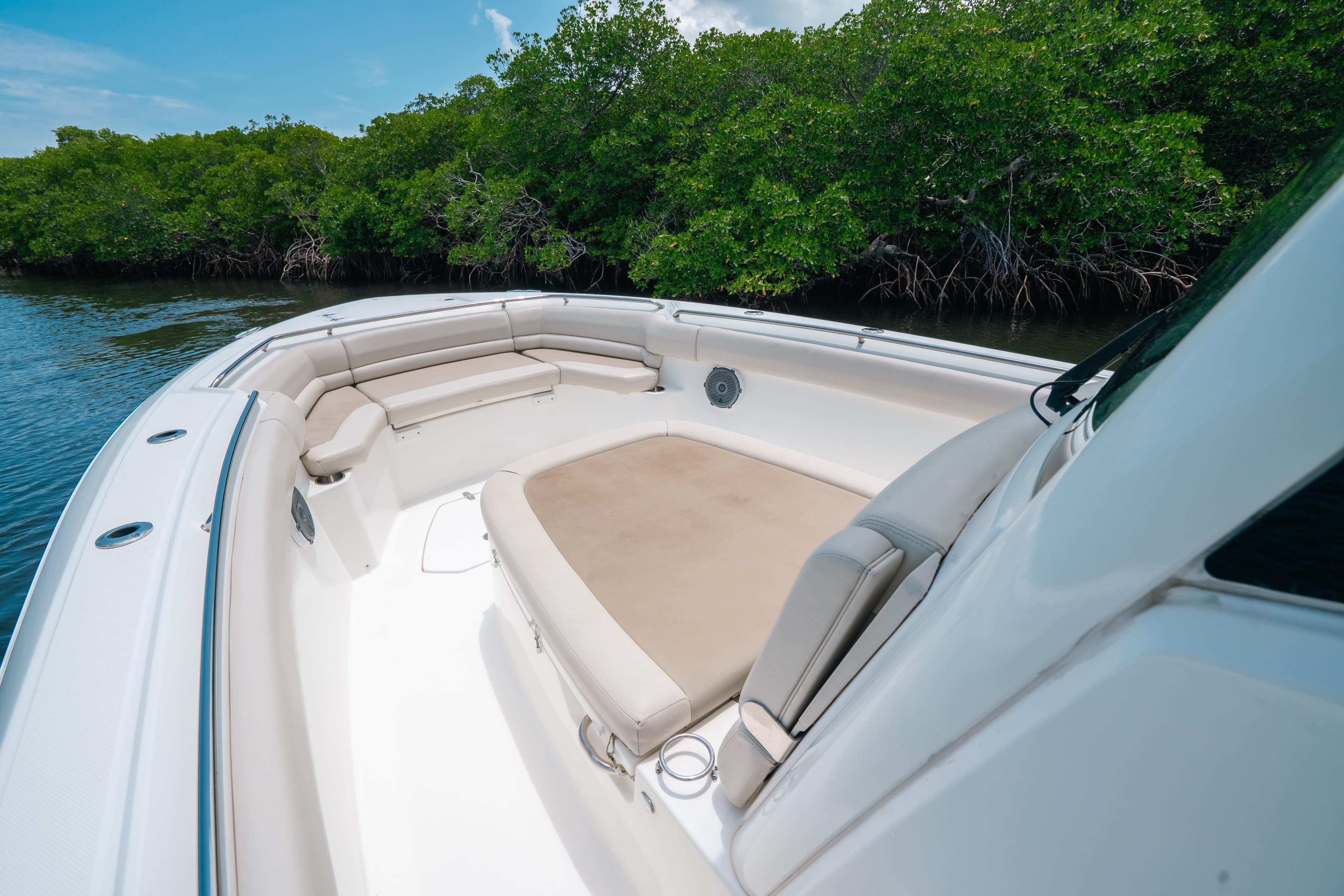 2019 Boston Whaler 330 Outrage boat interior with cushioned seating near lush mangroves.