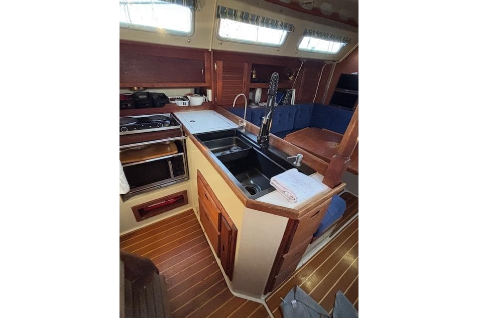 Interior of 1986 Catalina 36 MK I sailboat, featuring a compact kitchen and seating area.