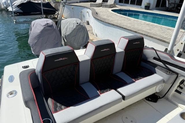 1996 Powerplay Powerboats 33 Sportfish with stylish seating near a poolside dock.