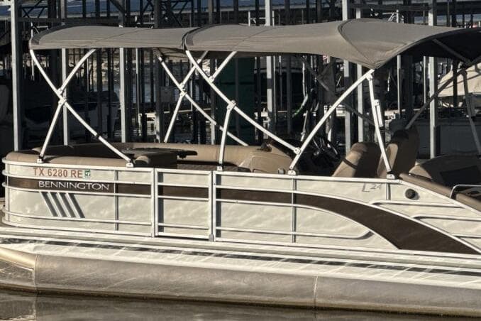 2021 Bennington L 24 Swingback pontoon boat docked with canopy.