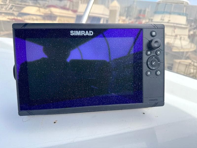 Simrad marine display on 1989 Carver 30 Santego boat, docked with other vessels.