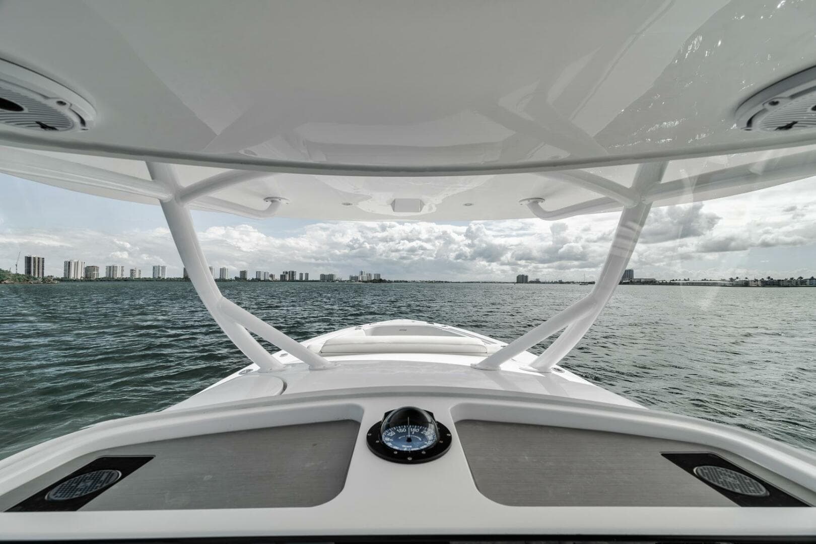 2023 Jupiter 40 boat on water, city skyline in background, overcast sky.