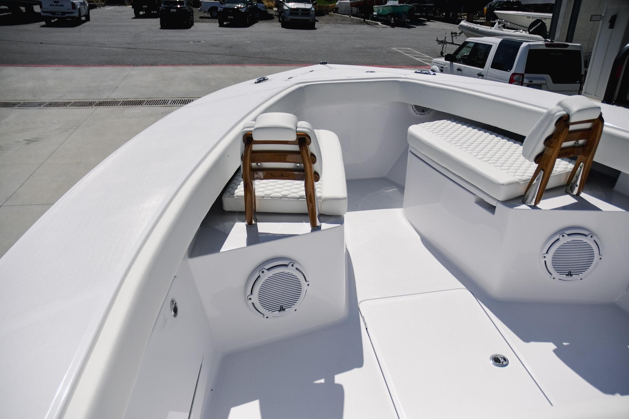 2026 Jupiter 32 boat interior with white seating and speakers, parked outdoors.