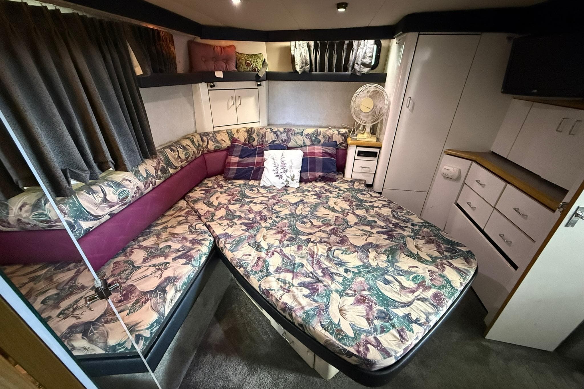 Cozy primary stateroom in 1991 Bayliner 4387 Motoryacht with floral bedding and ample storage.