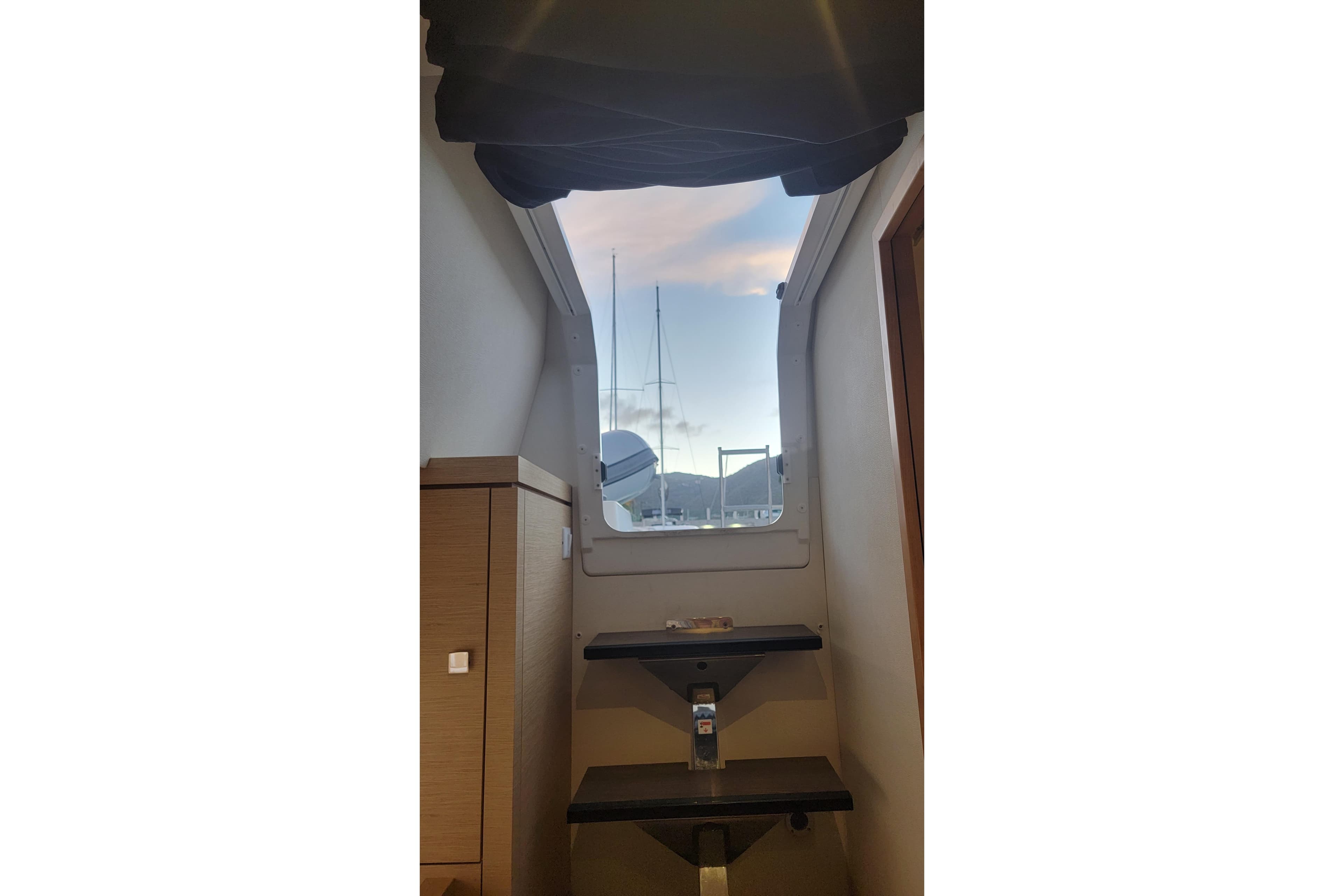 Interior view of 2019 Fountaine Pajot Saona 47 yacht, showcasing stairs and window.
