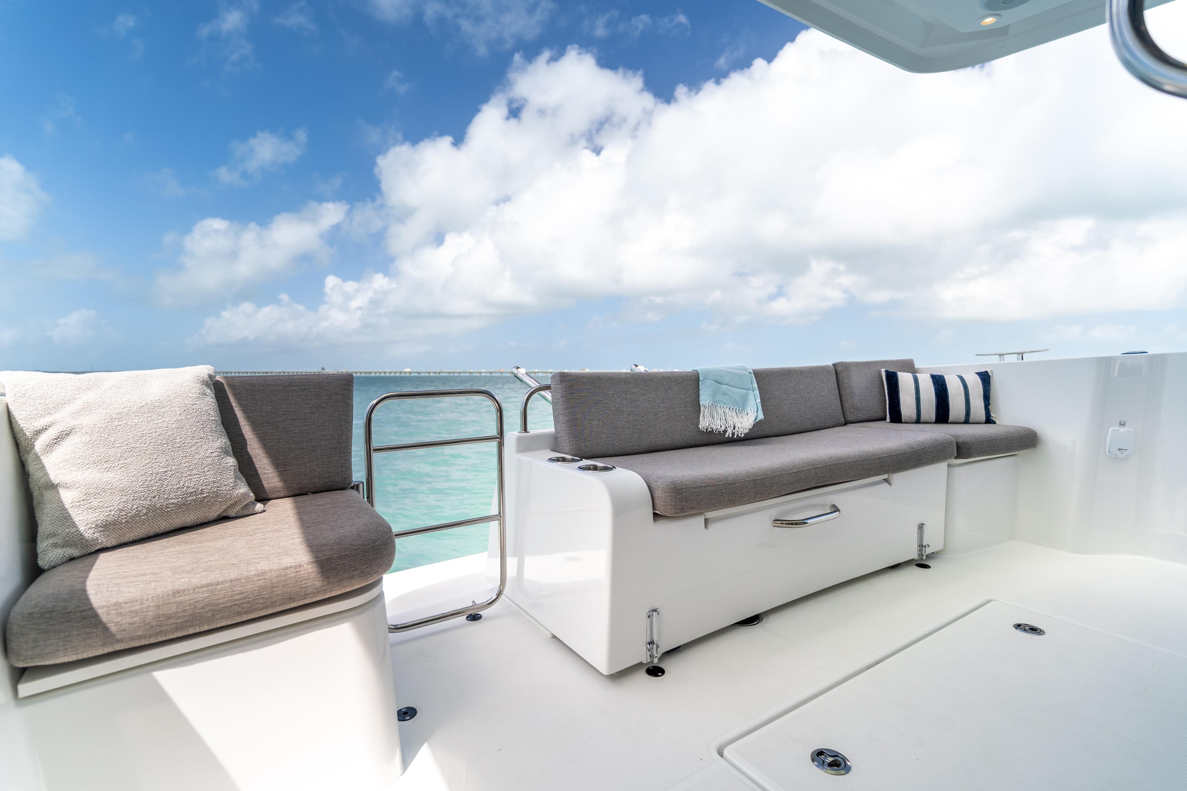 Luxurious seating area on 2026 Beneteau Swift Trawler 37 Fly, under clear blue skies.