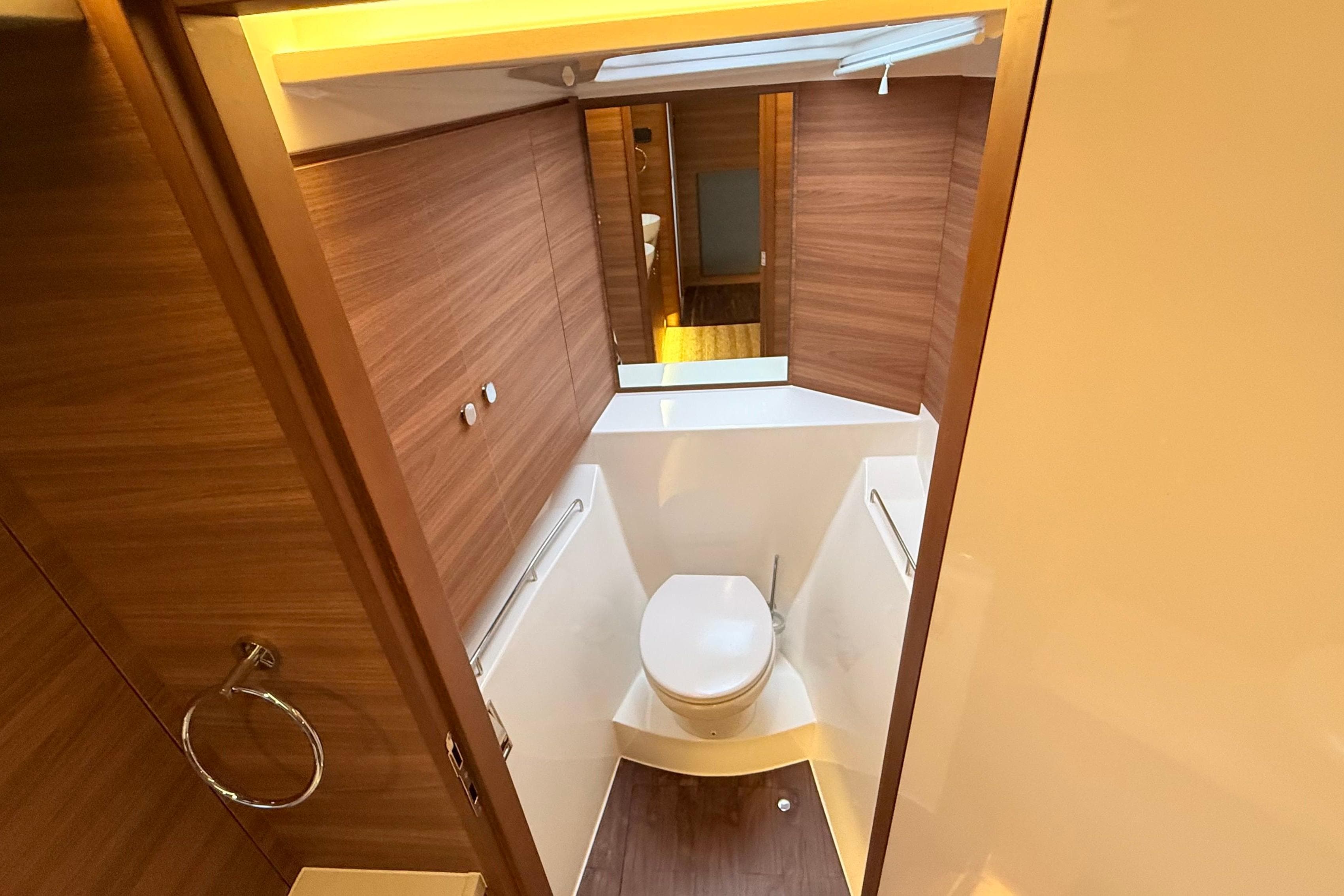 Modern bathroom interior on 2025 Aquila 50 Yacht, featuring wood paneling and sleek design.
