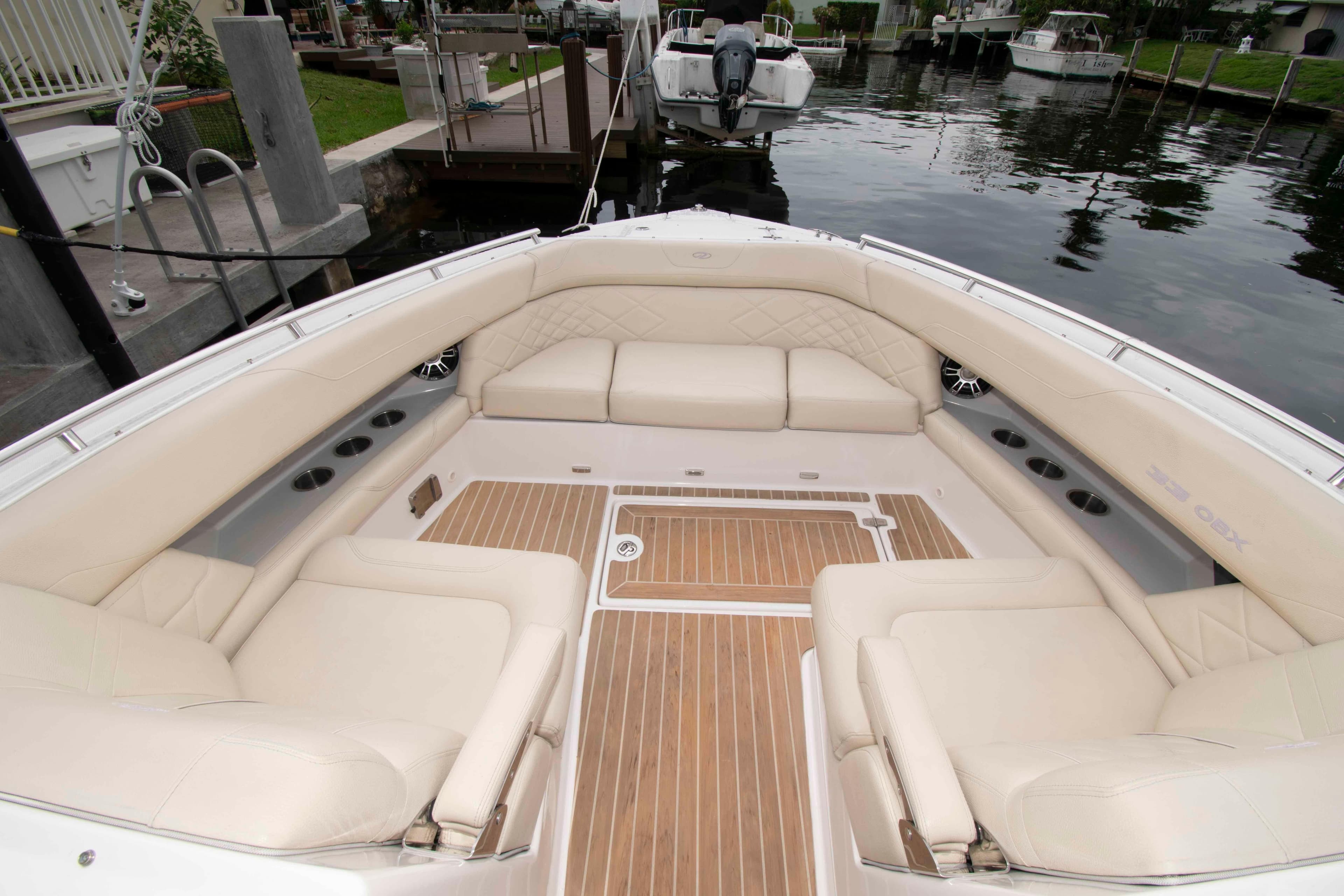 Luxurious seating area on a 2019 Regal 33 OBX boat, docked by the water.