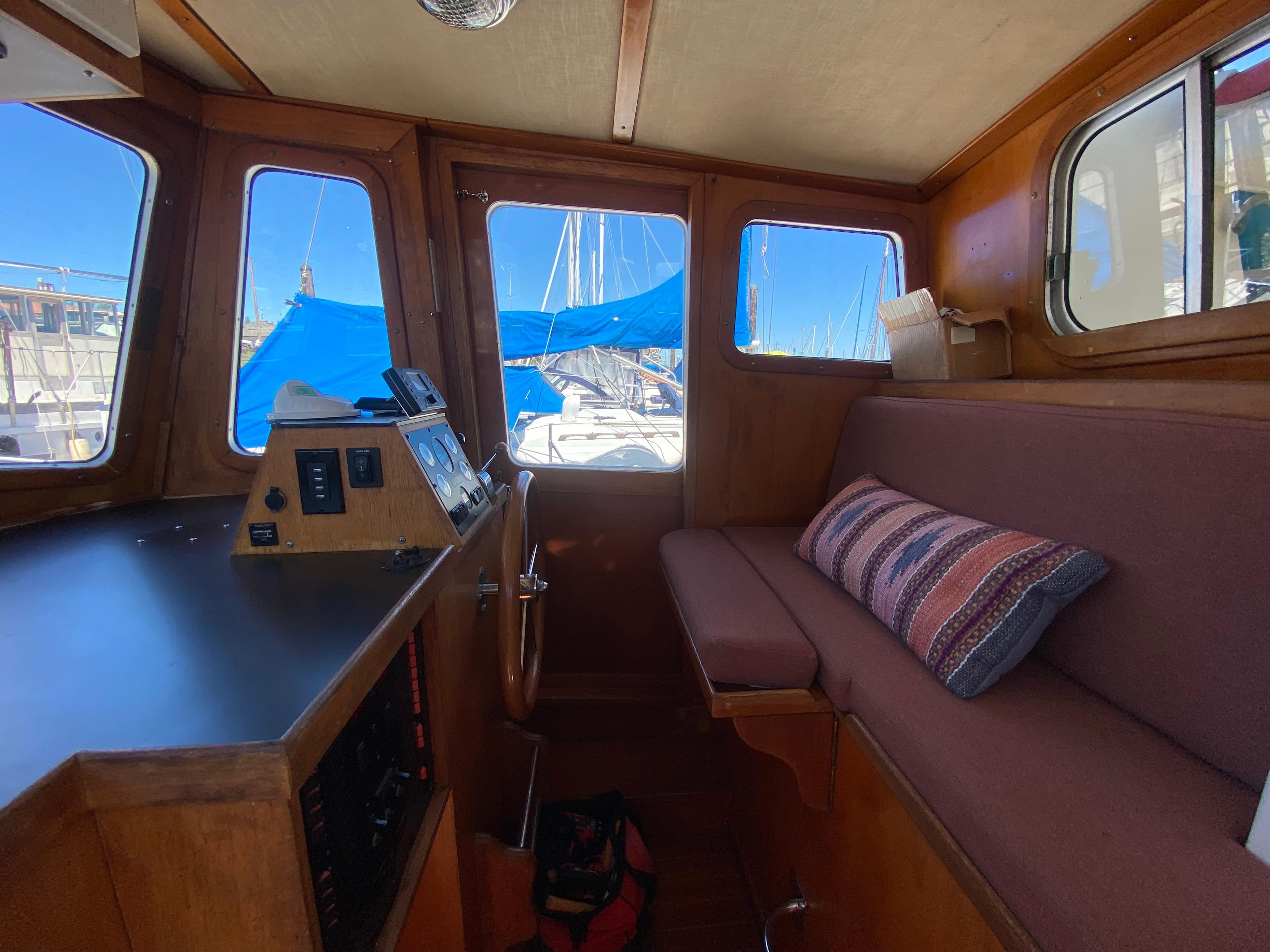 1986 Transpacific Marine Eagle boat interior with wooden helm, cushioned seating, and nautical controls.