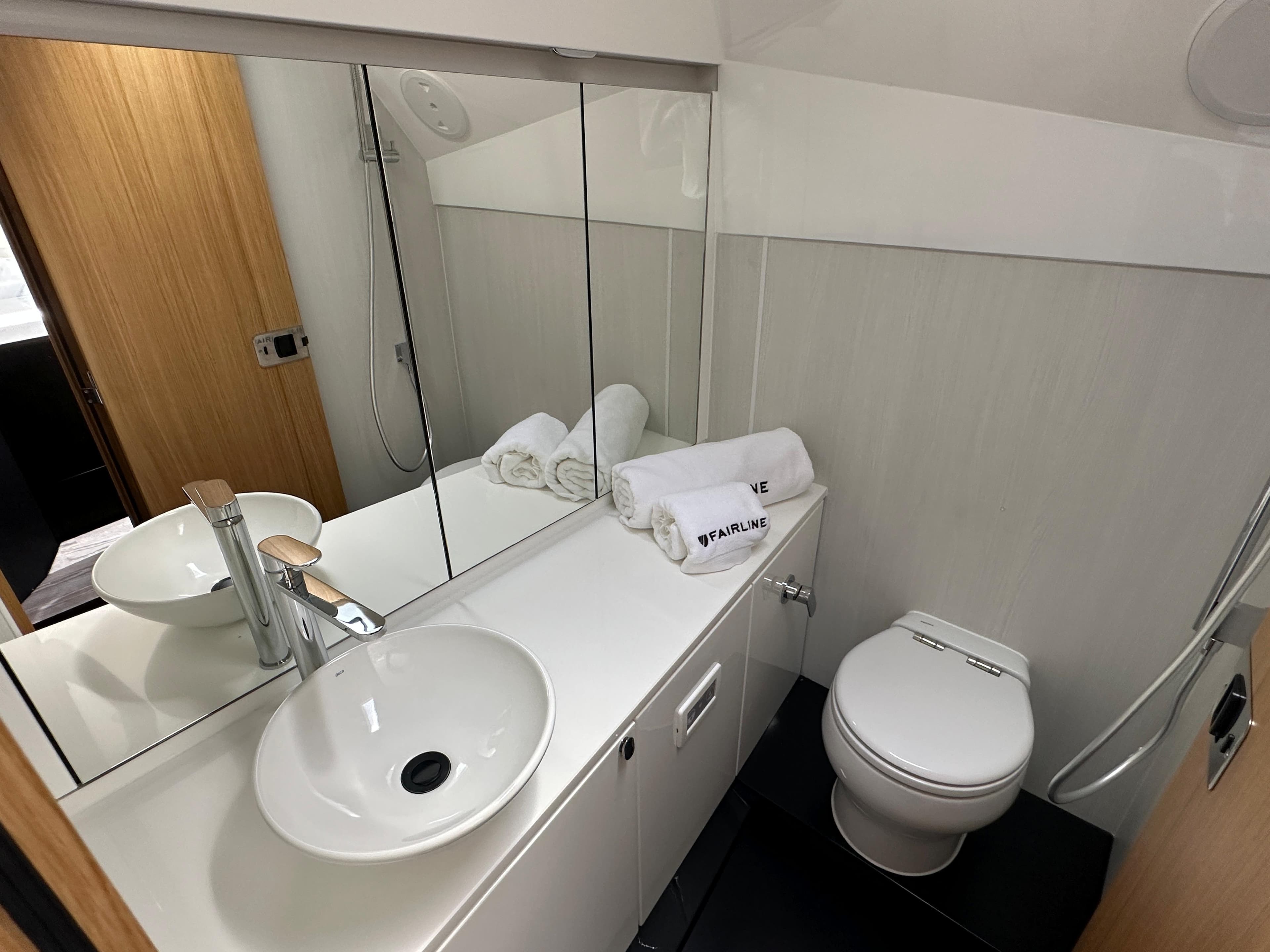 Modern bathroom in 2023 Fairline F//Line 33 Outboard yacht with sink, toilet, and mirror.