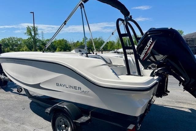 2026 Bayliner M17 boat with Mercury engine on trailer, parked outdoors.